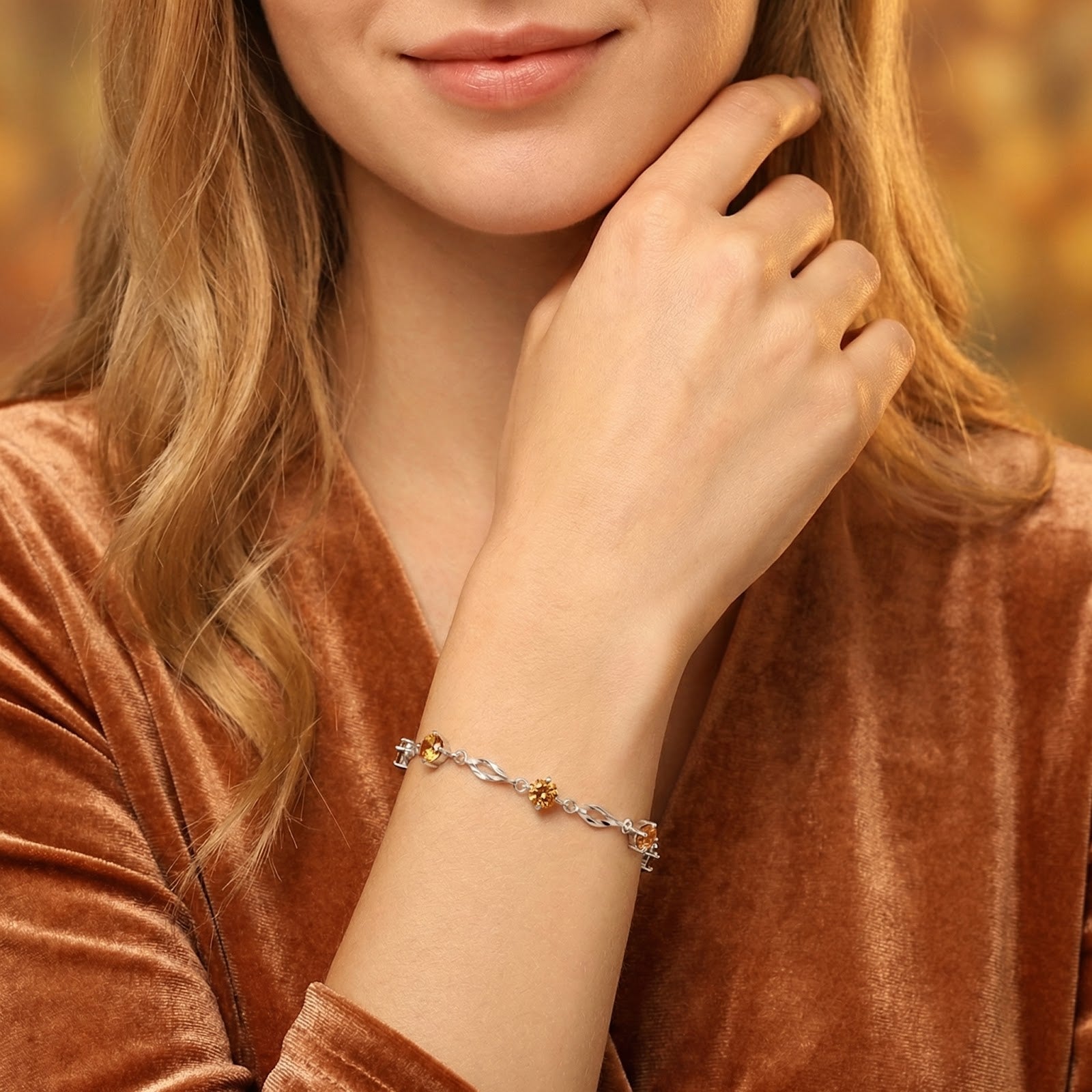 Woman wearing the Zenara station bracelet in sterling silver with round golden simulated topaz stones on her wrist.
