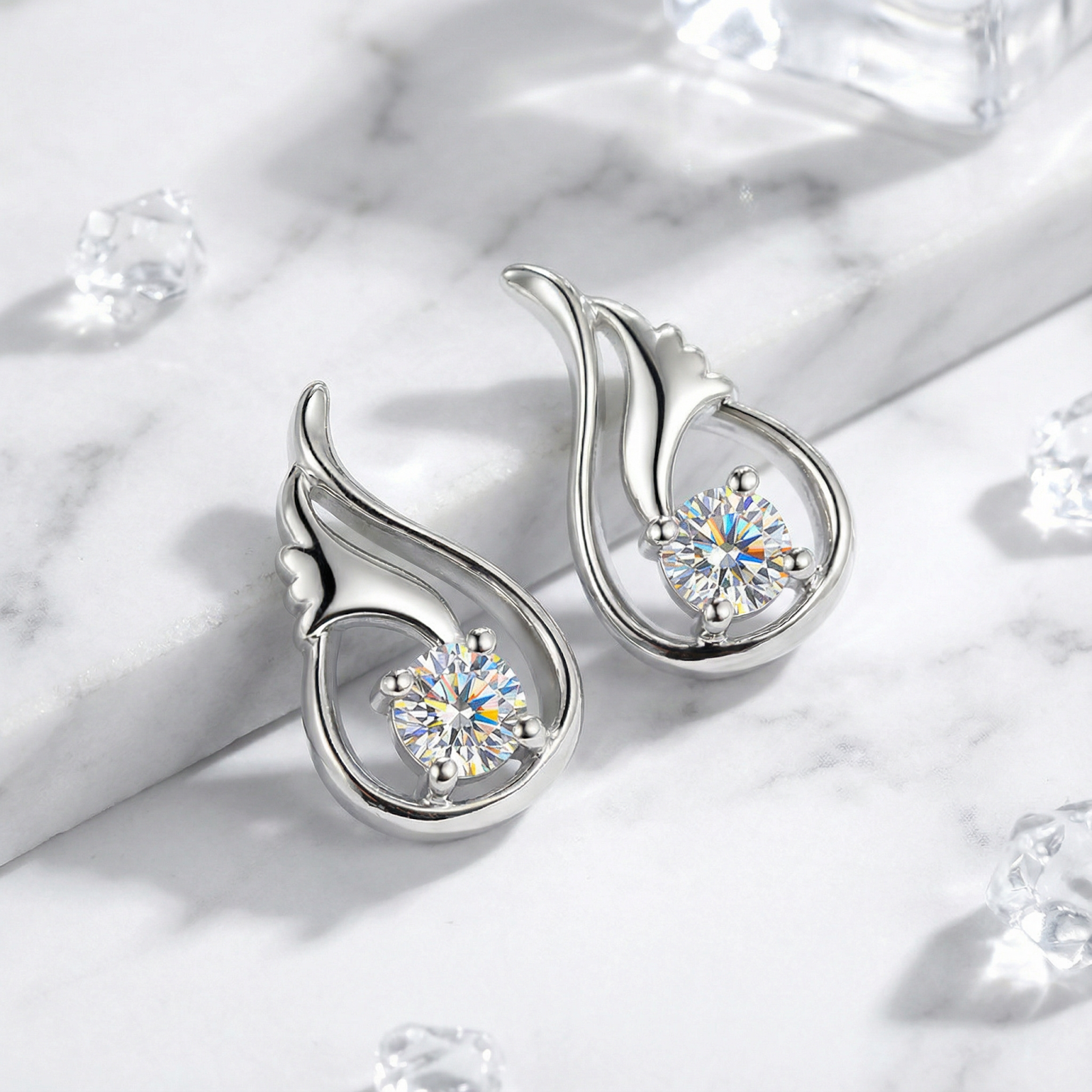 Angled view of sterling silver Florielle Bud earrings with round cut zirconia on a marble background.