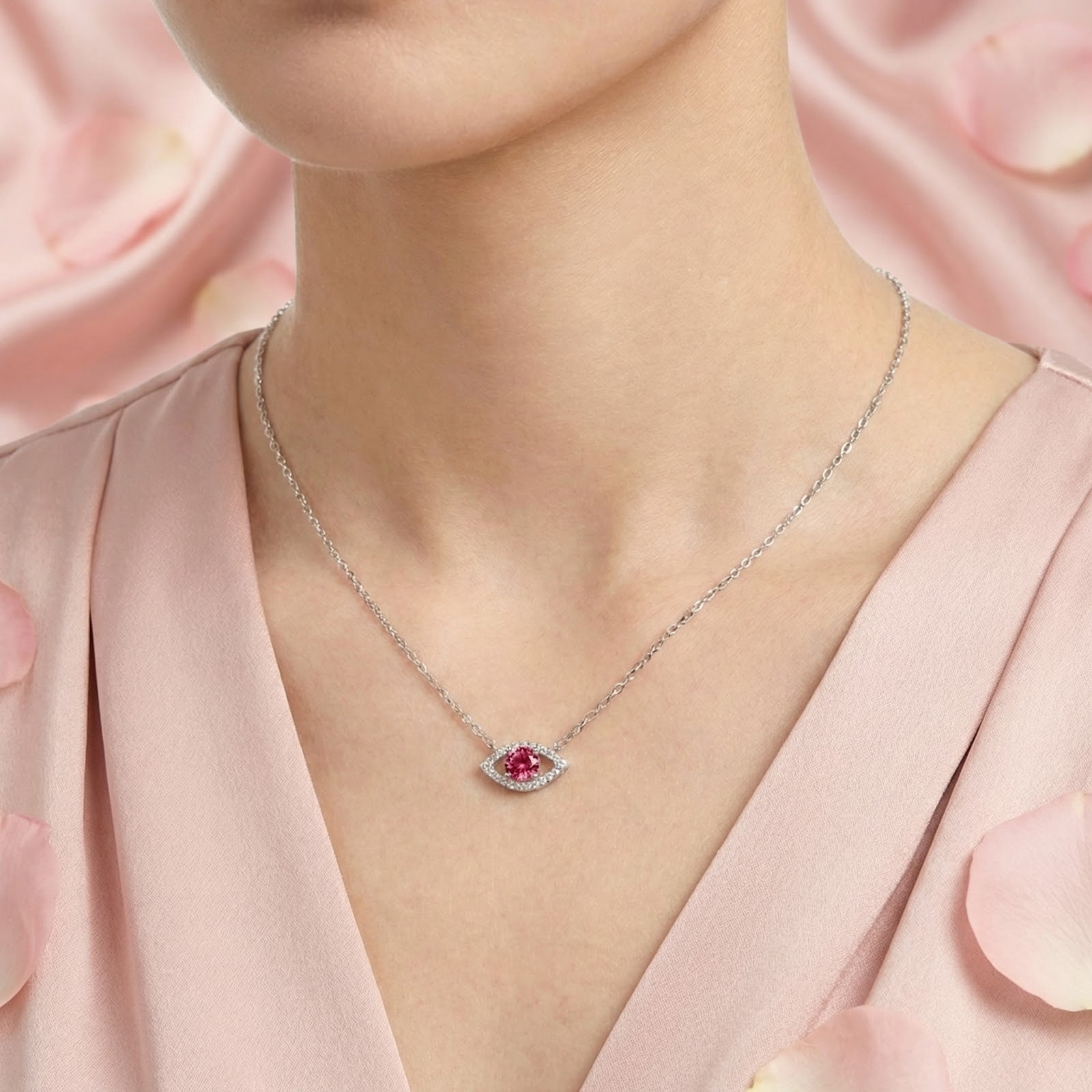 Round cut pink moissanite eye pendant in sterling silver worn on a woman's neck.