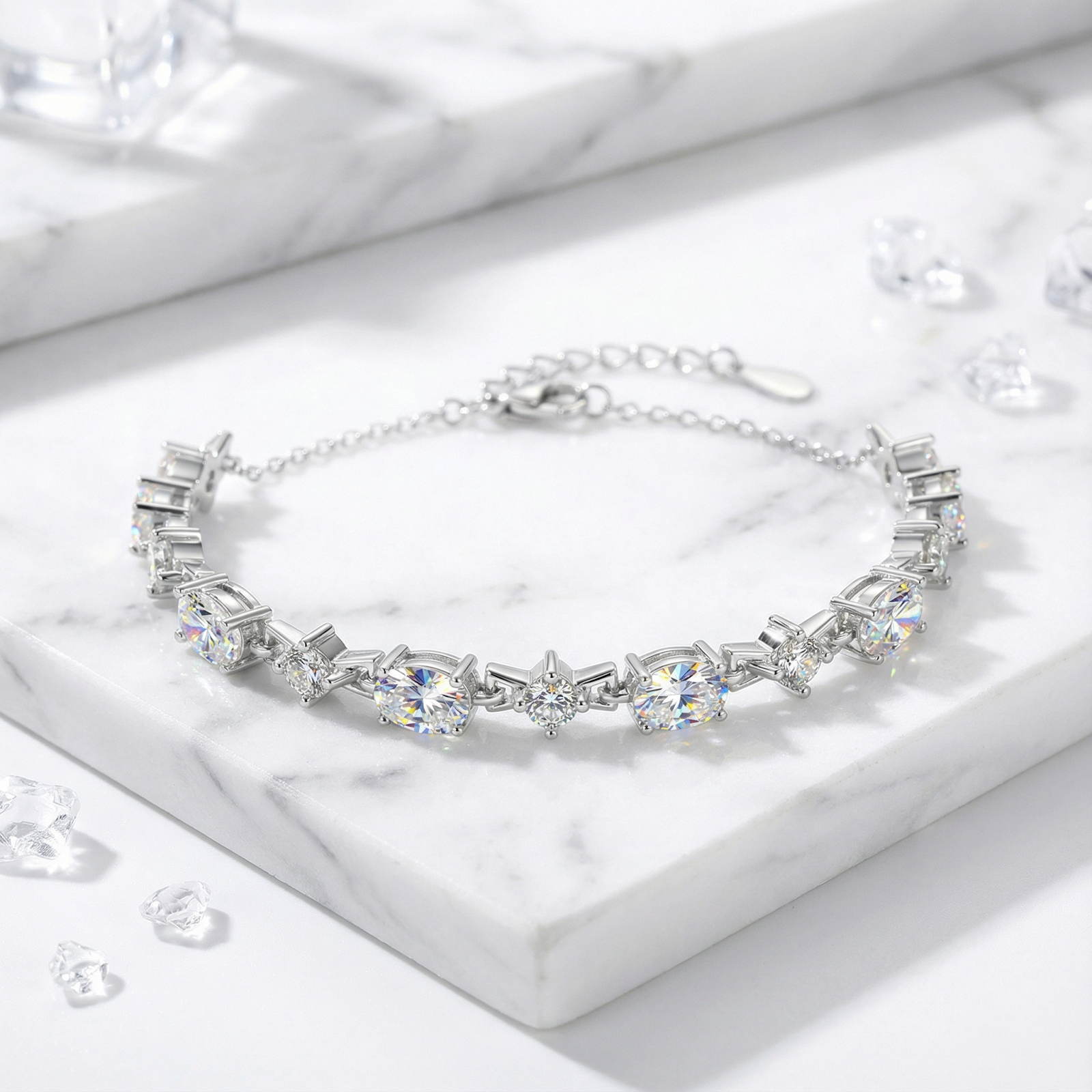 Sterling silver station bracelet with alternating round and oval zirconia and extender chain on marble.
