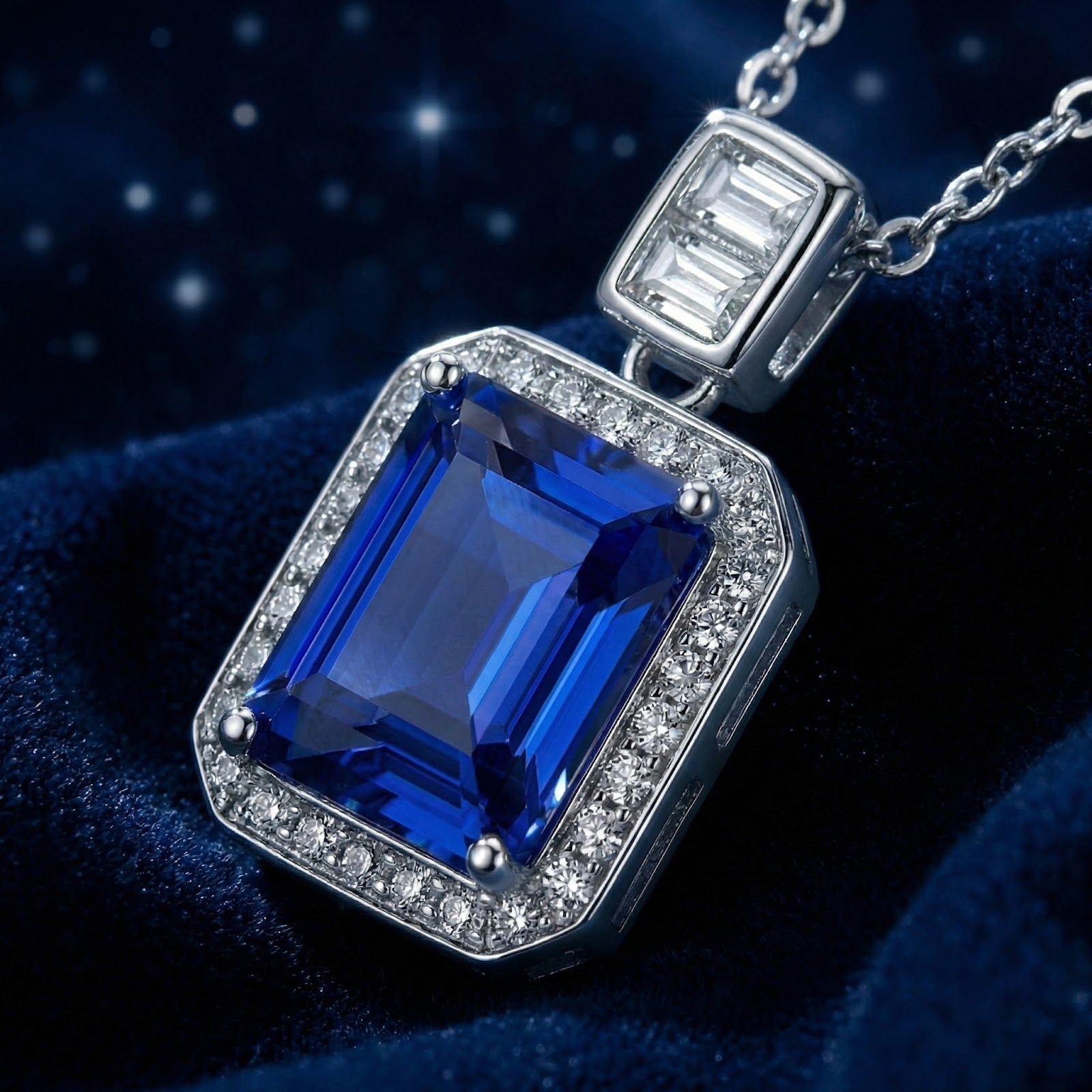 Macro view of the emerald cut simulated sapphire and halo setting on the sterling silver Rosamund pendant.