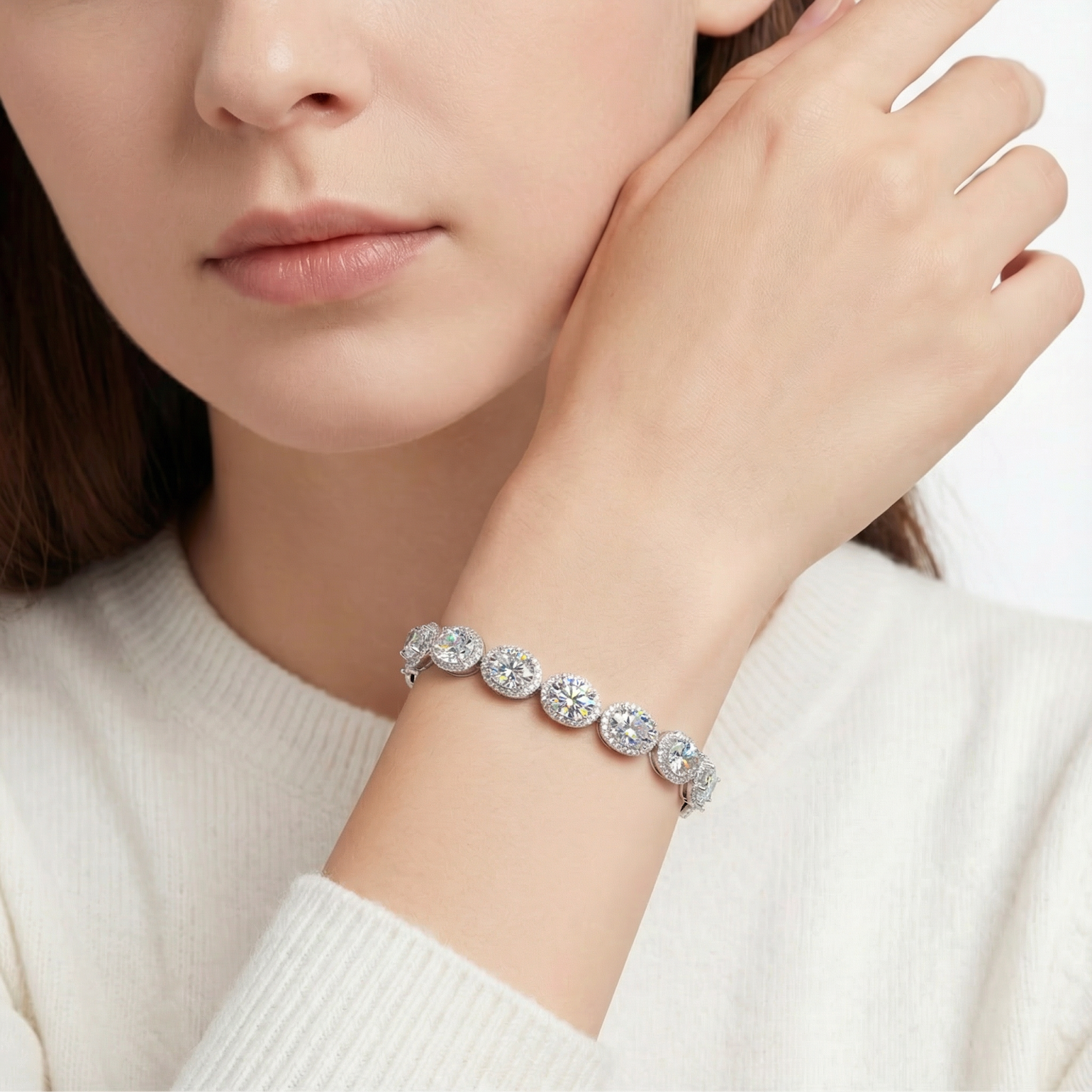 Aethelra halo bracelet with oval-cut 5A zirconia in sterling silver worn on a woman's wrist with a white sweater.
