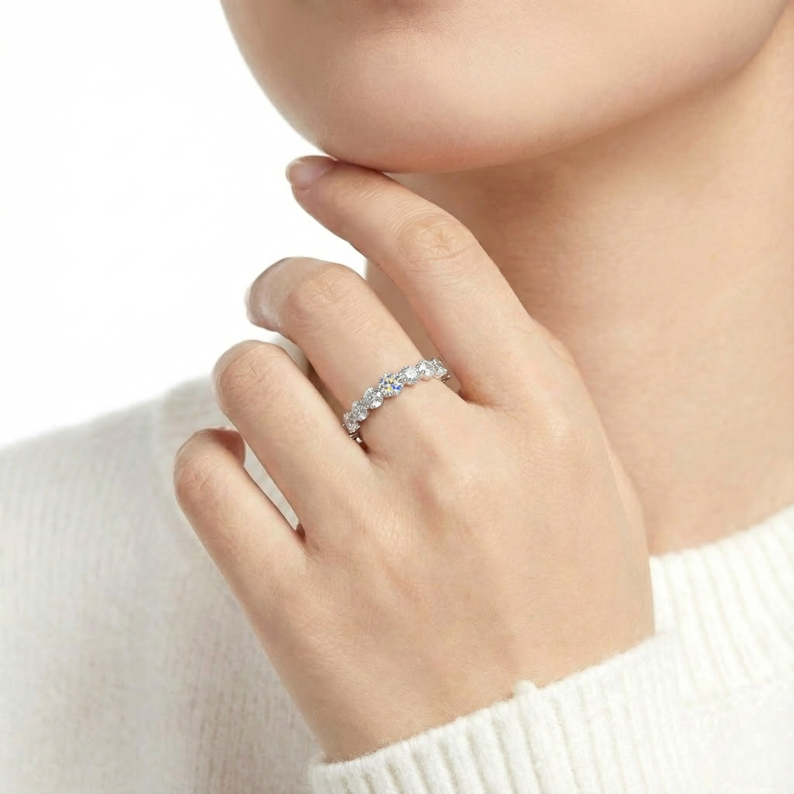 Close-up of the Lucianne S925 sterling silver simulated diamond ring worn on a model's hand near her chin.