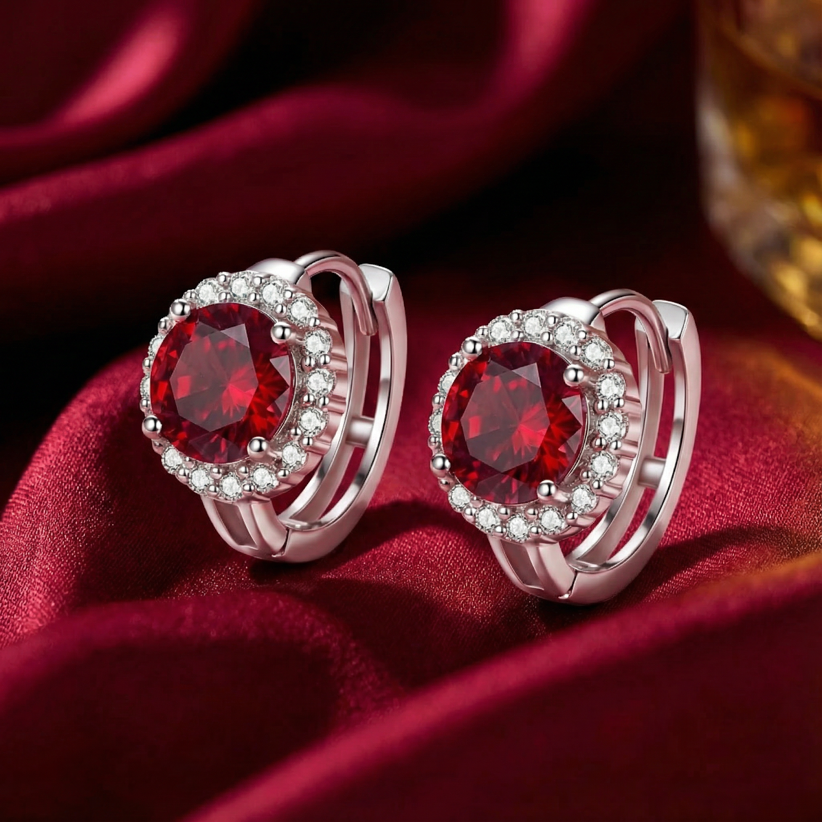 Macro view of the silver setting and round red ruby stone on a halo stud earring.