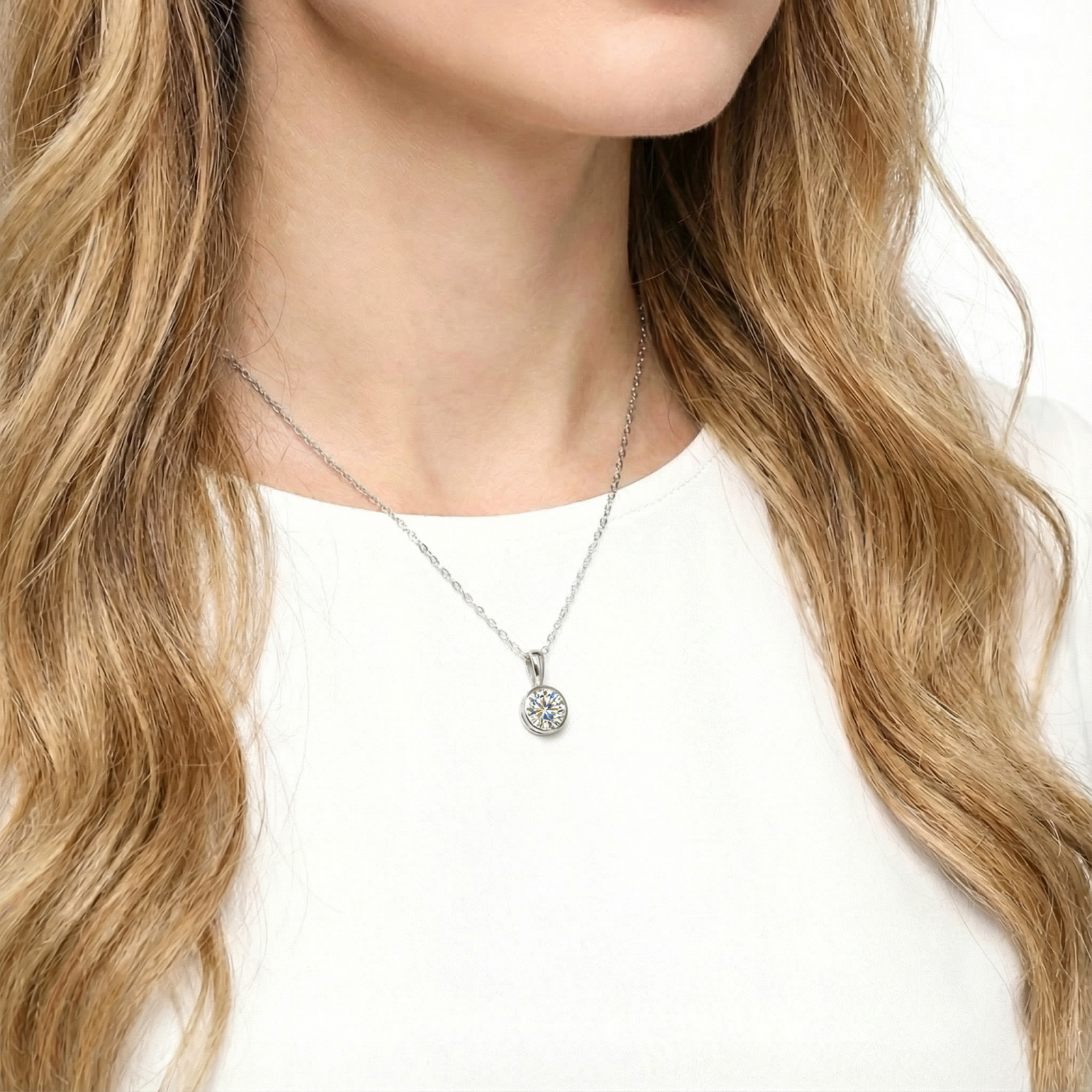 Woman wearing the Kaia bezel sterling silver necklace with a round simulated diamond pendant.