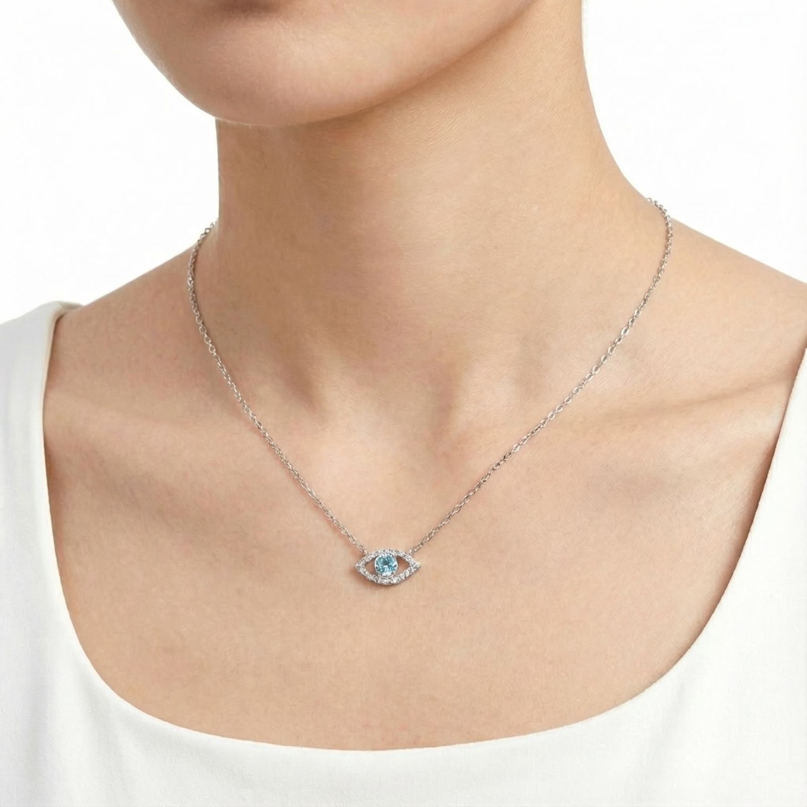 Sterling silver Elara Eye necklace with a round cut simulated aquamarine worn on a woman's neck.