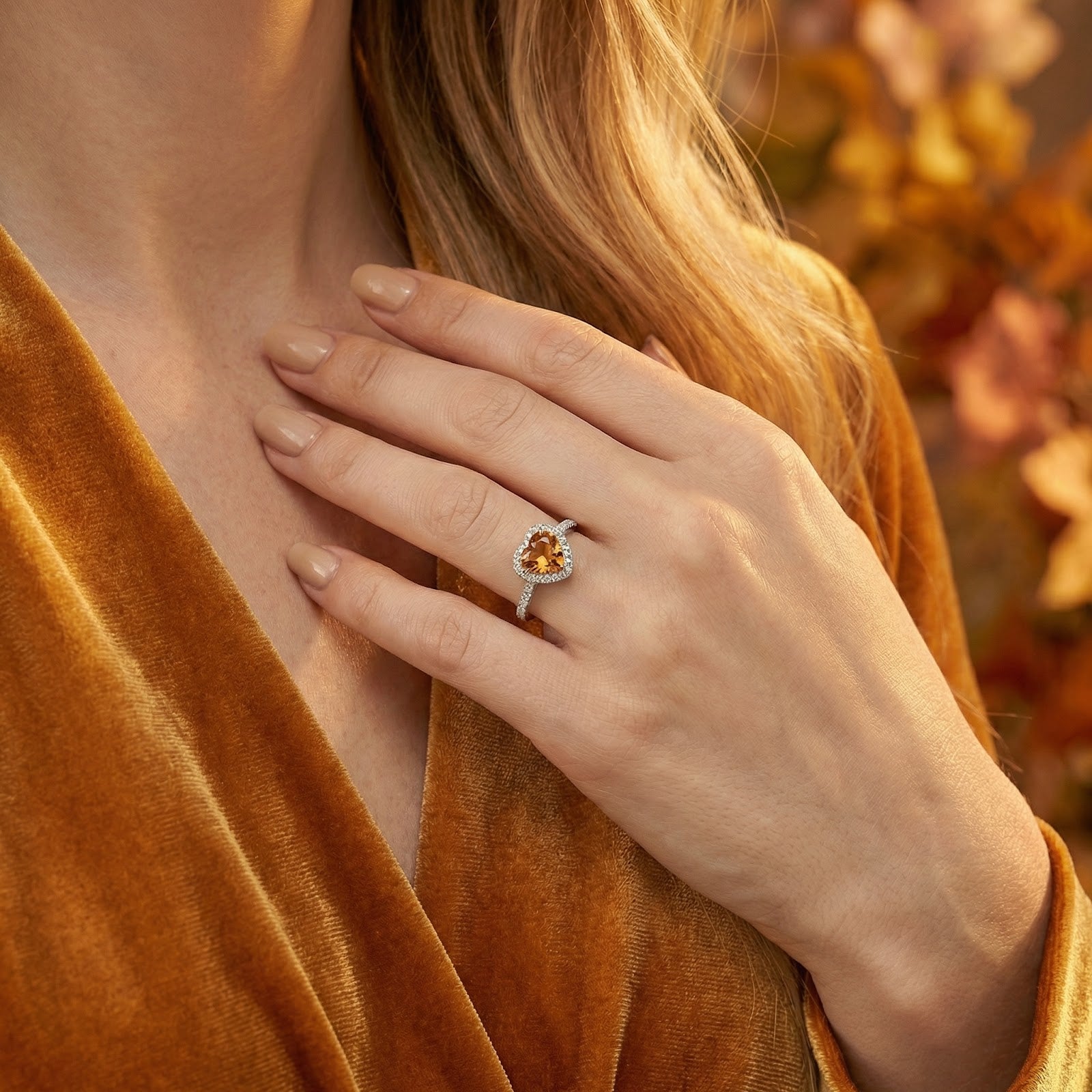 Close-up of the heart-cut simulated topaz halo ring in sterling silver worn on a model's hand.