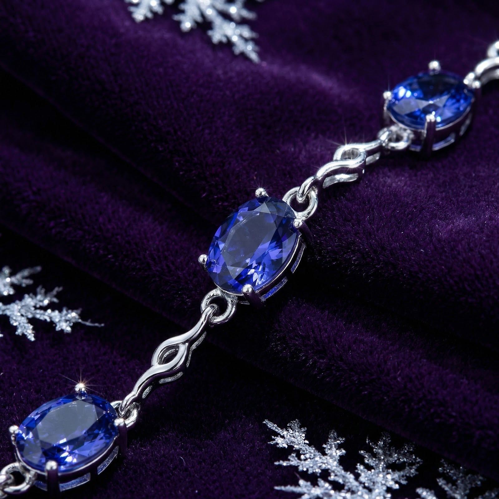 Close-up of oval-cut simulated tanzanite stones and sterling silver links on the Melisara station bracelet.