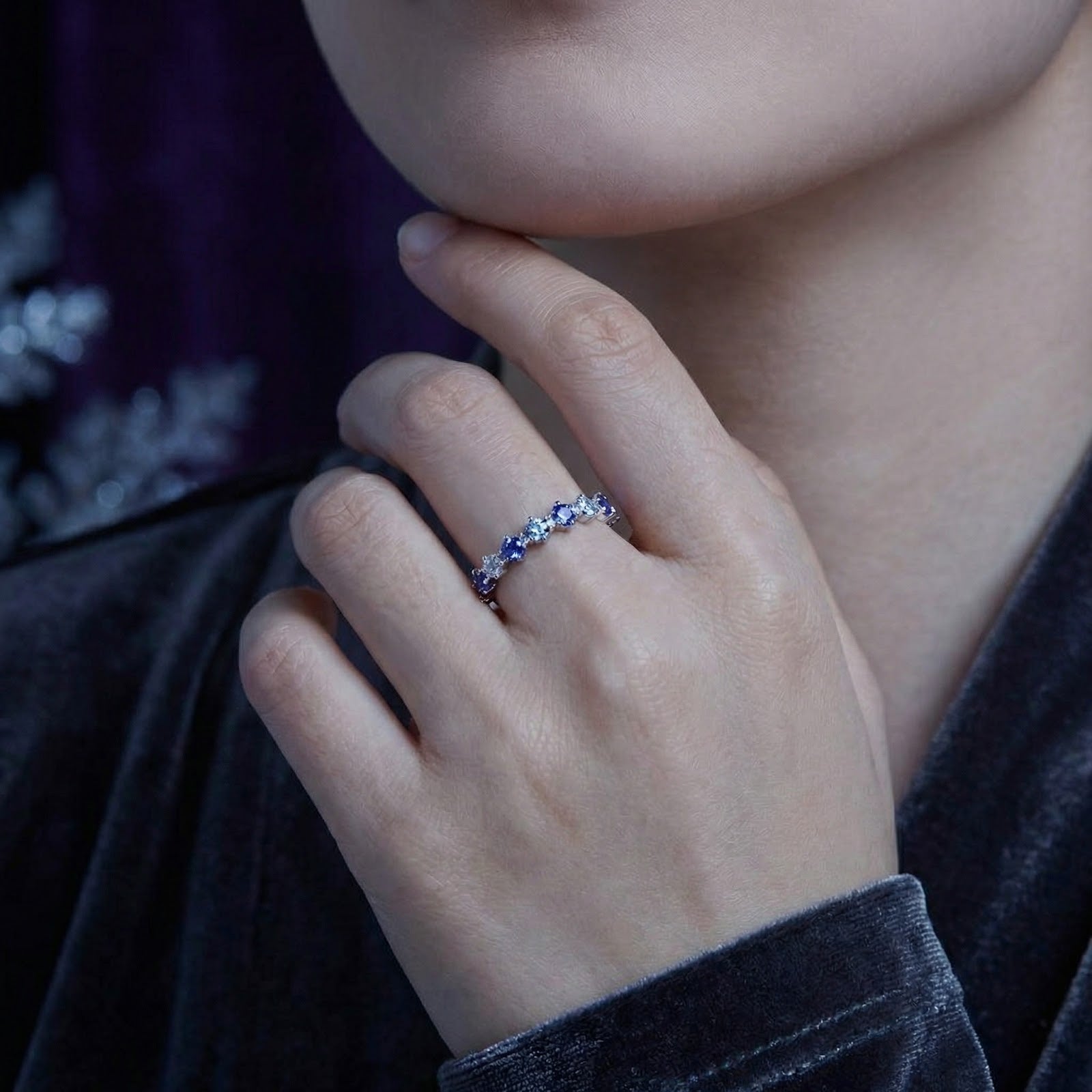 Model wearing the S925 sterling silver Kyrianne Row ring with alternating blue and clear stones on her hand.
