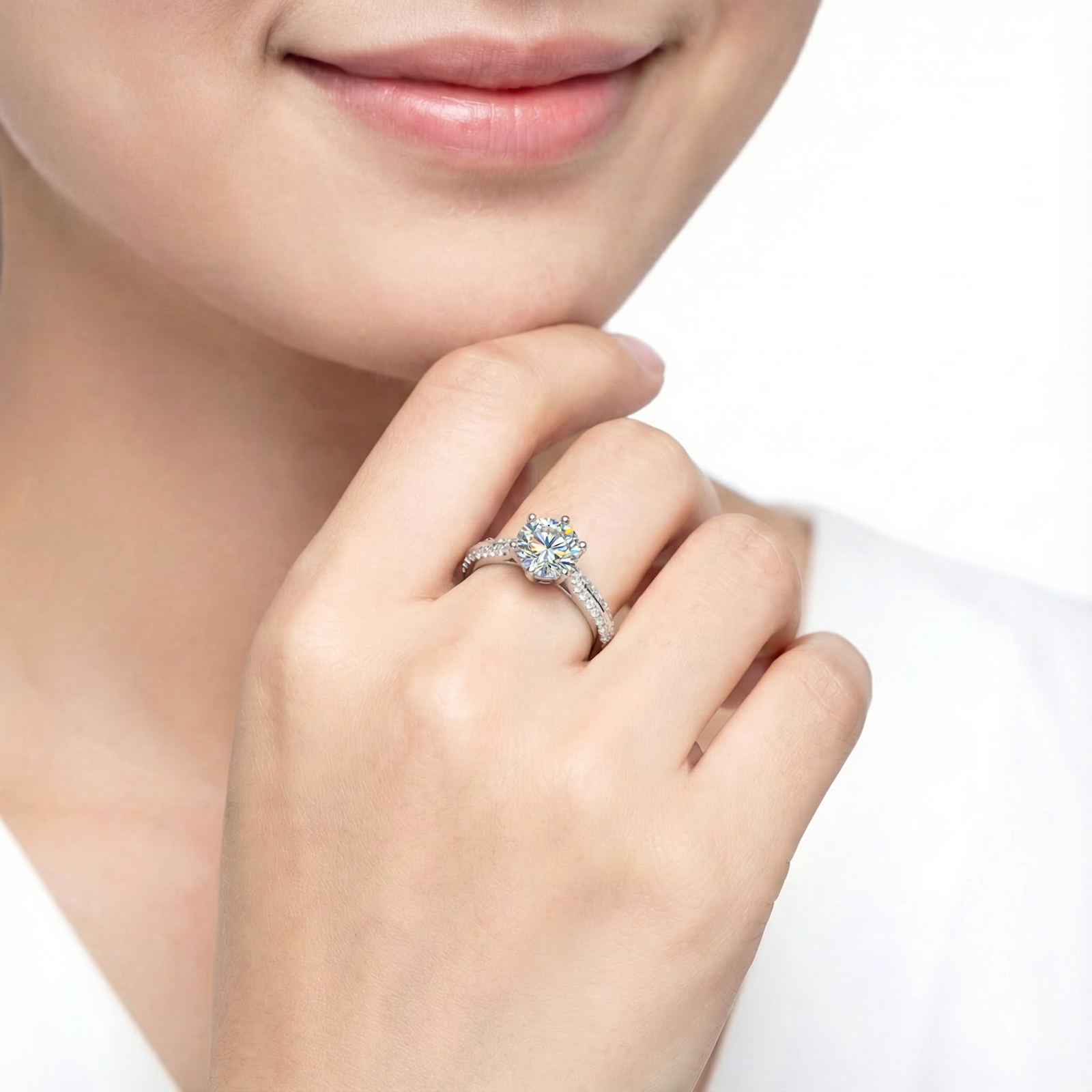 Woman wearing the Kalysta round simulated diamond solitaire ring in sterling silver on her finger.