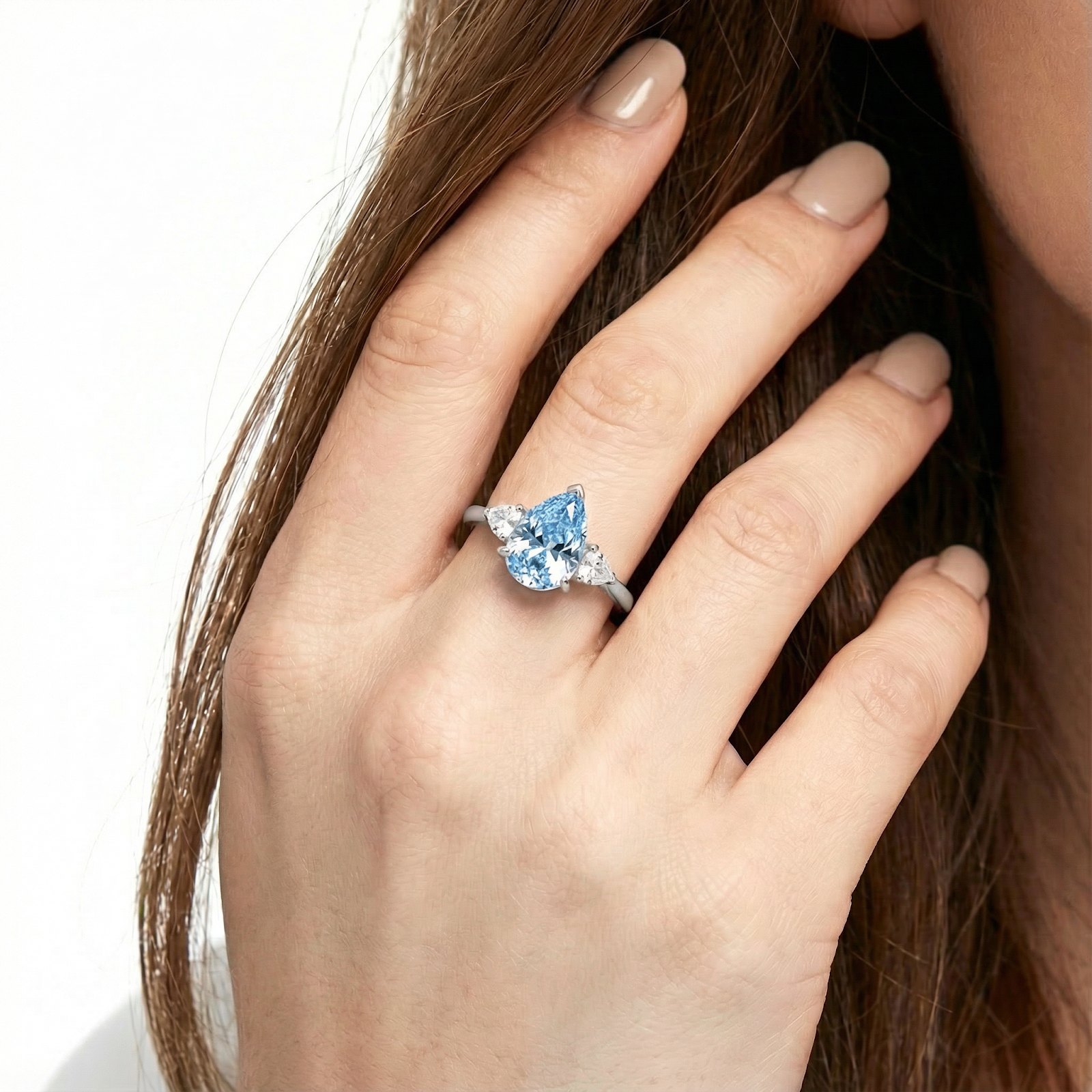Model wearing the pear cut simulated aquamarine sterling silver ring on her ring finger.