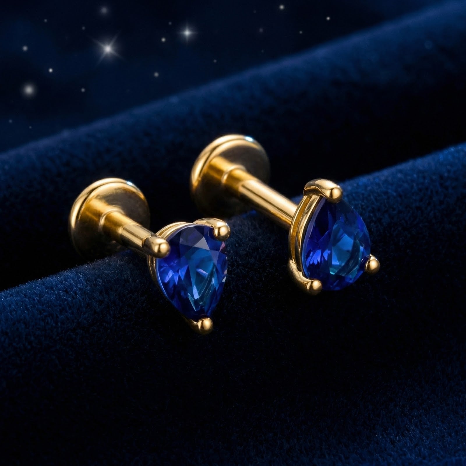 Pear-cut simulated sapphire stud earrings in 18K gold vermeil with flat backs on blue velvet.