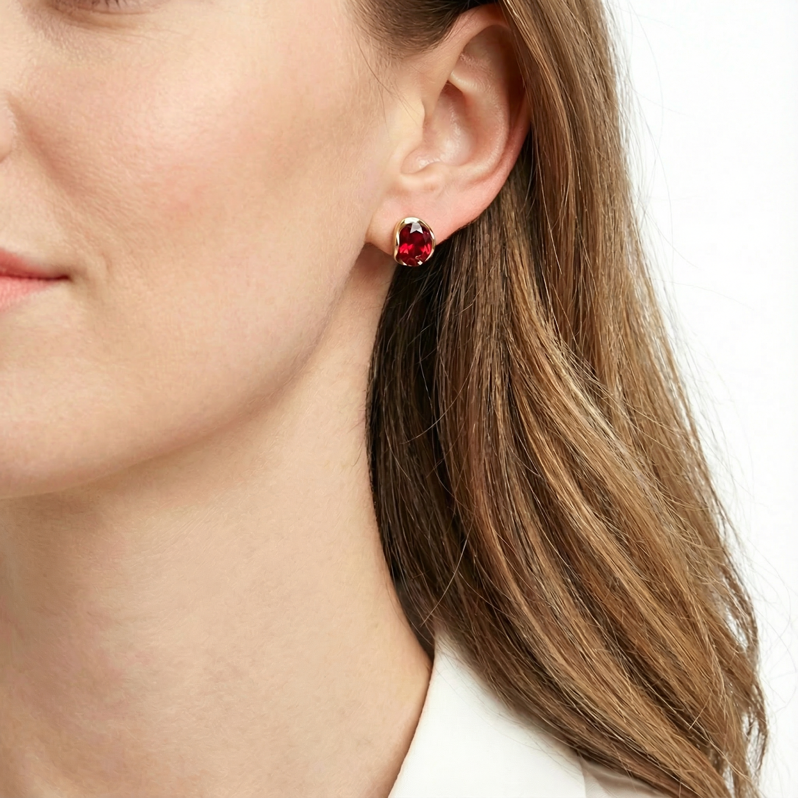 Model wearing the Julara 18K gold vermeil stud earrings featuring vibrant red simulated rubies.