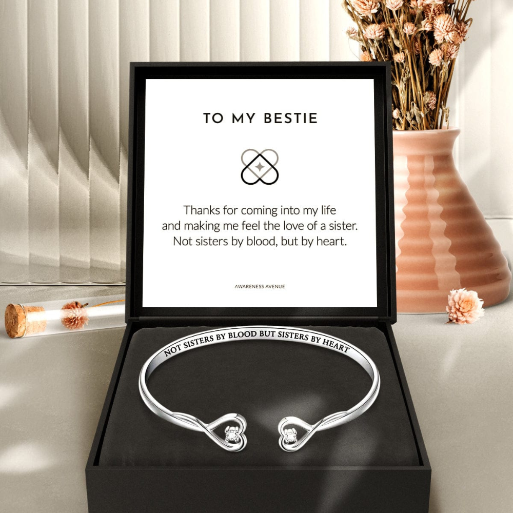 A silver bracelet with two hearts, presented in a black box with a message card that reads 'To my Bestie'.