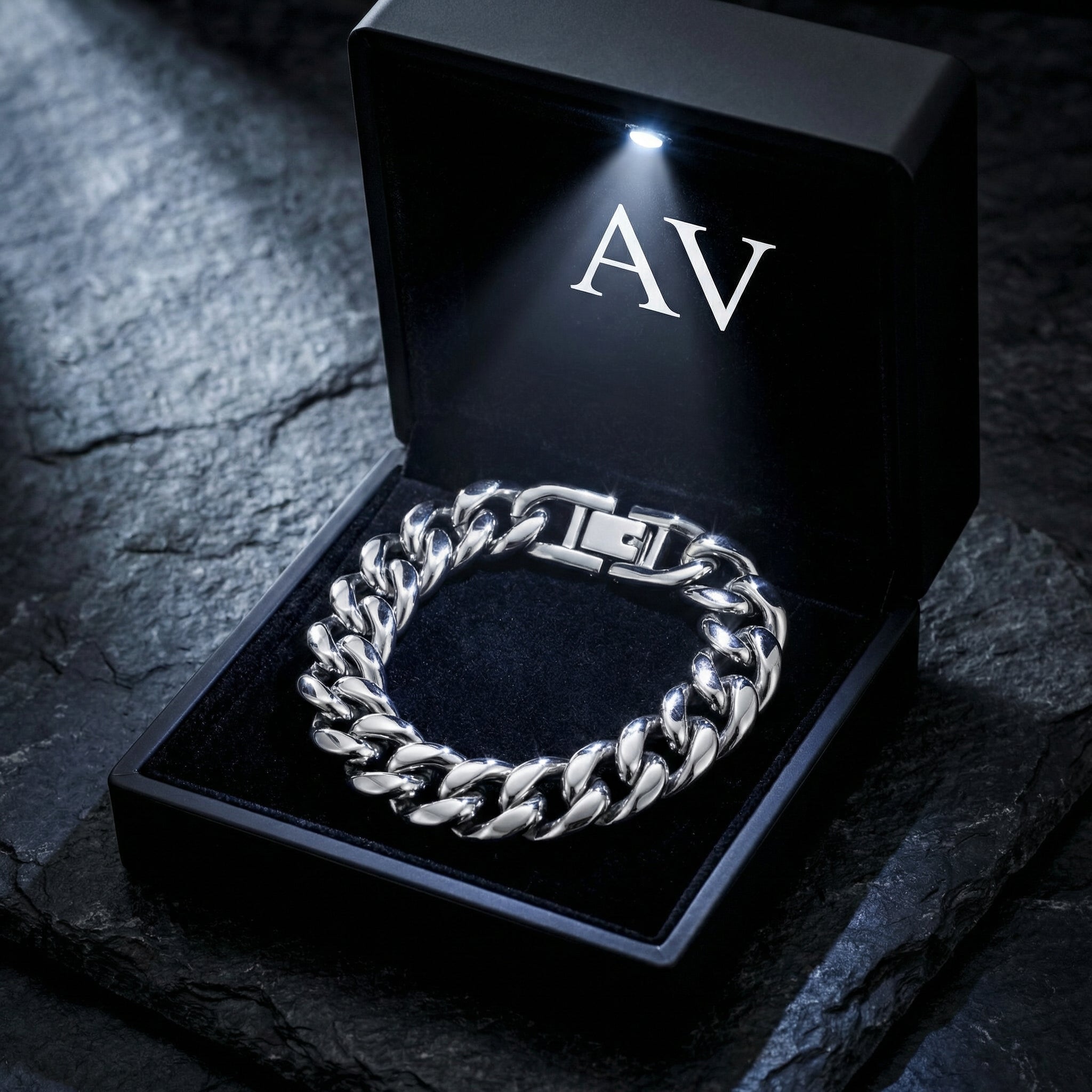 Silver 12mm stainless steel Cuban link bracelet inside a black LED-lit branded gift box.