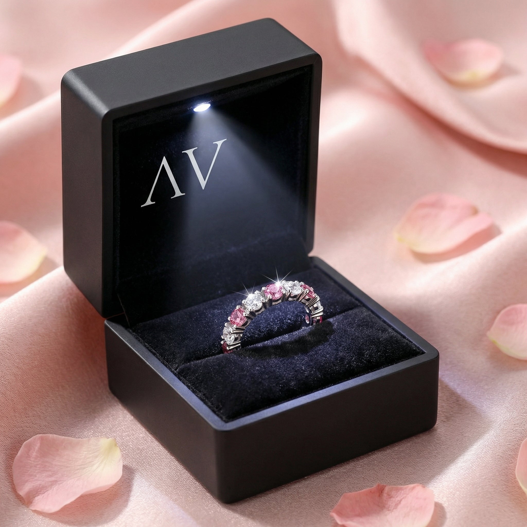 Sterling silver pink tourmaline ring inside a black LED-lit gift box on a pink fabric background.