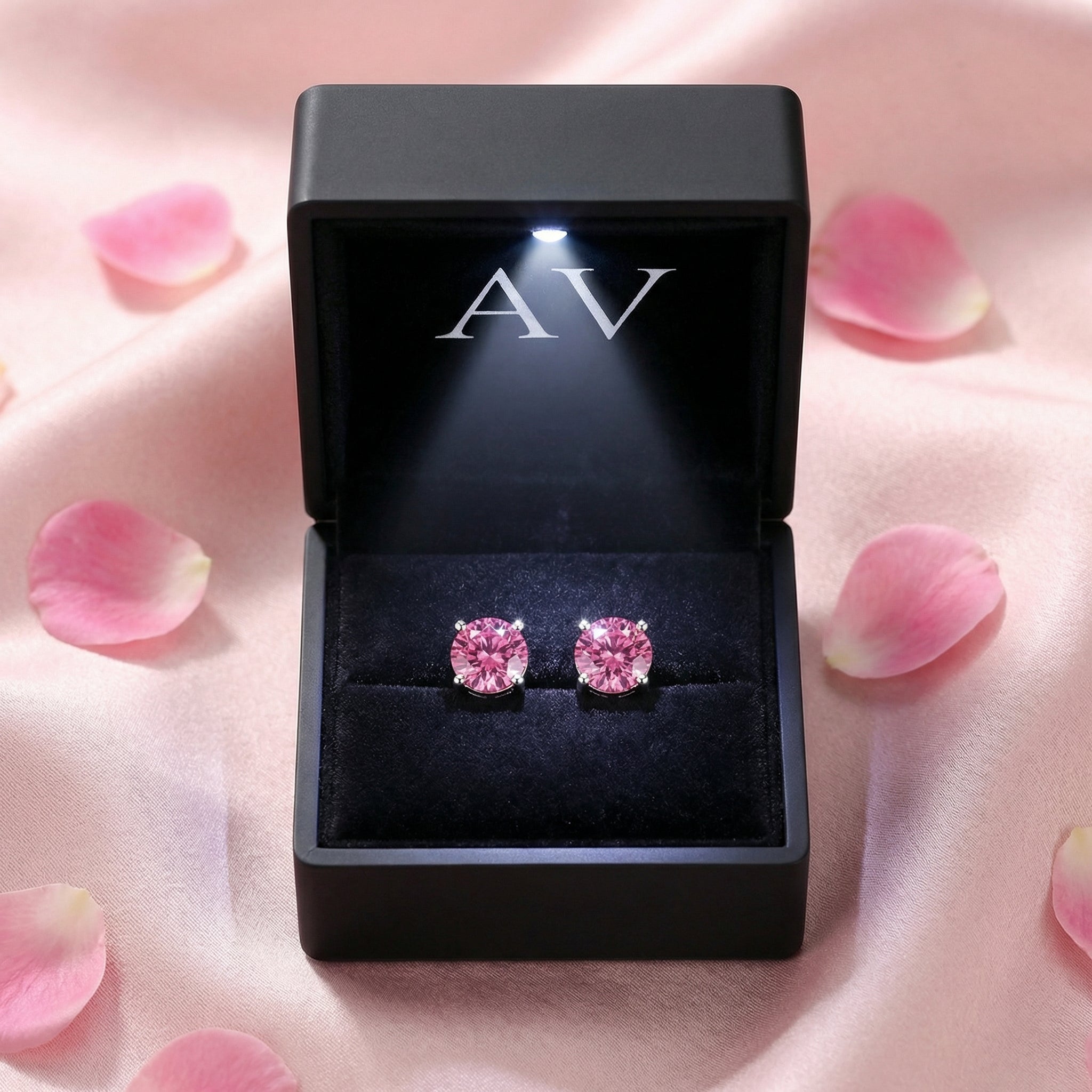 Round cut simulated pink tourmaline stud earrings in sterling silver inside a black LED-lit gift box.