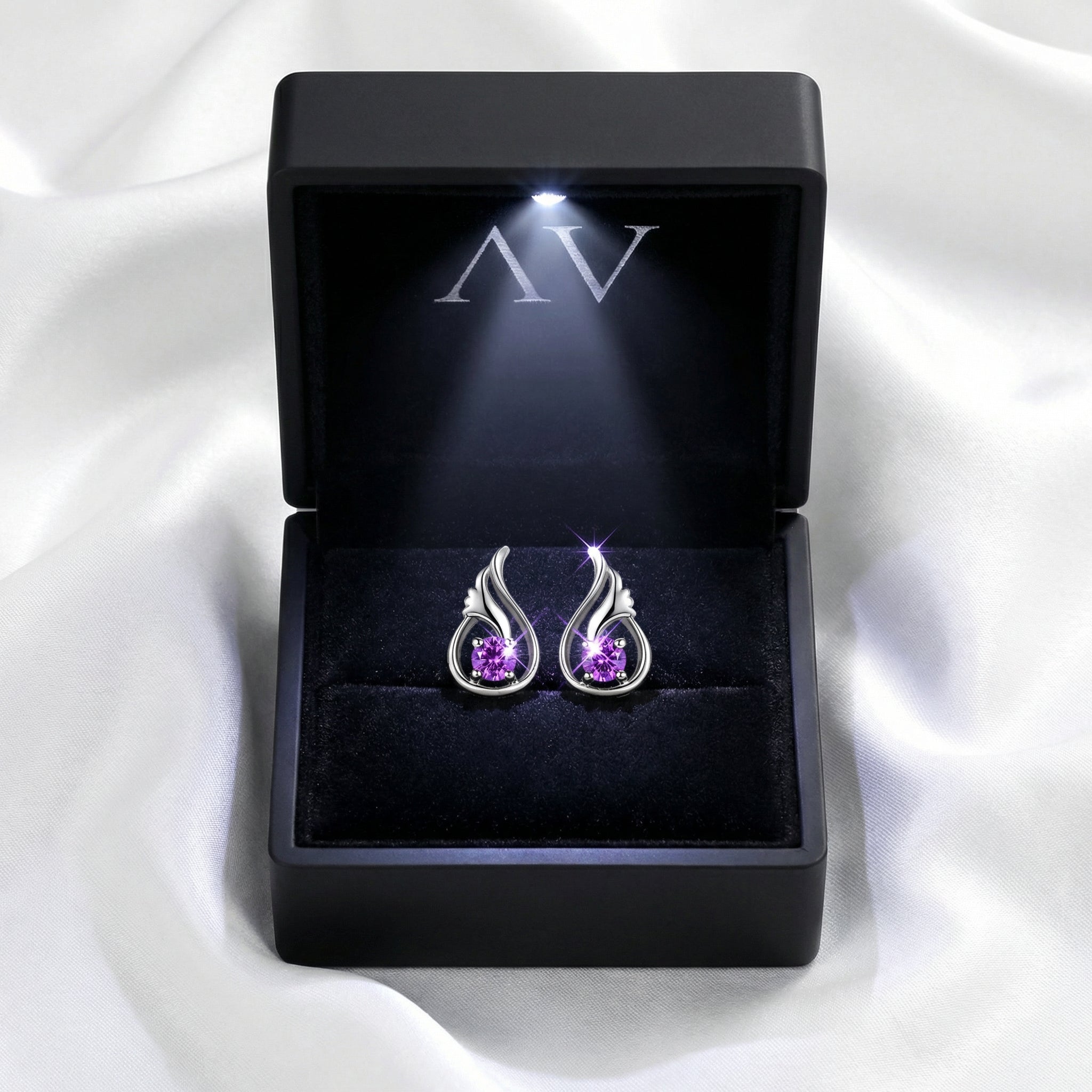 S925 sterling silver Lysithea drop earrings with simulated amethyst in a black lighted jewelry presentation box.