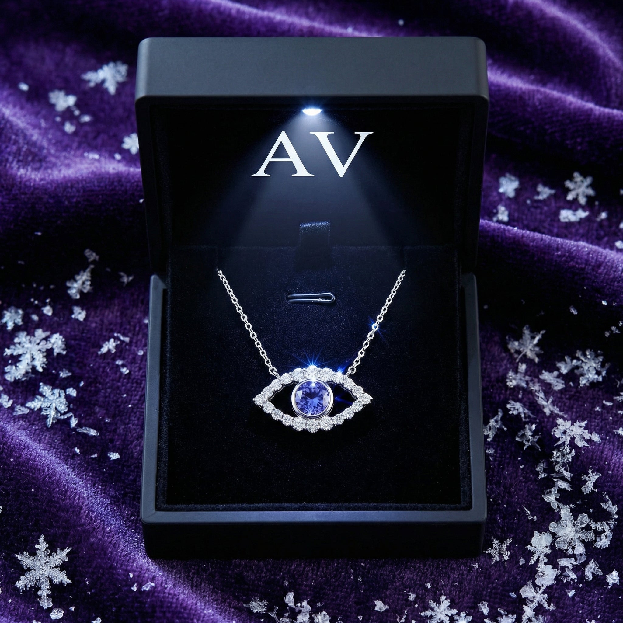 Silver simulated tanzanite evil eye necklace inside a lighted black jewelry gift box.