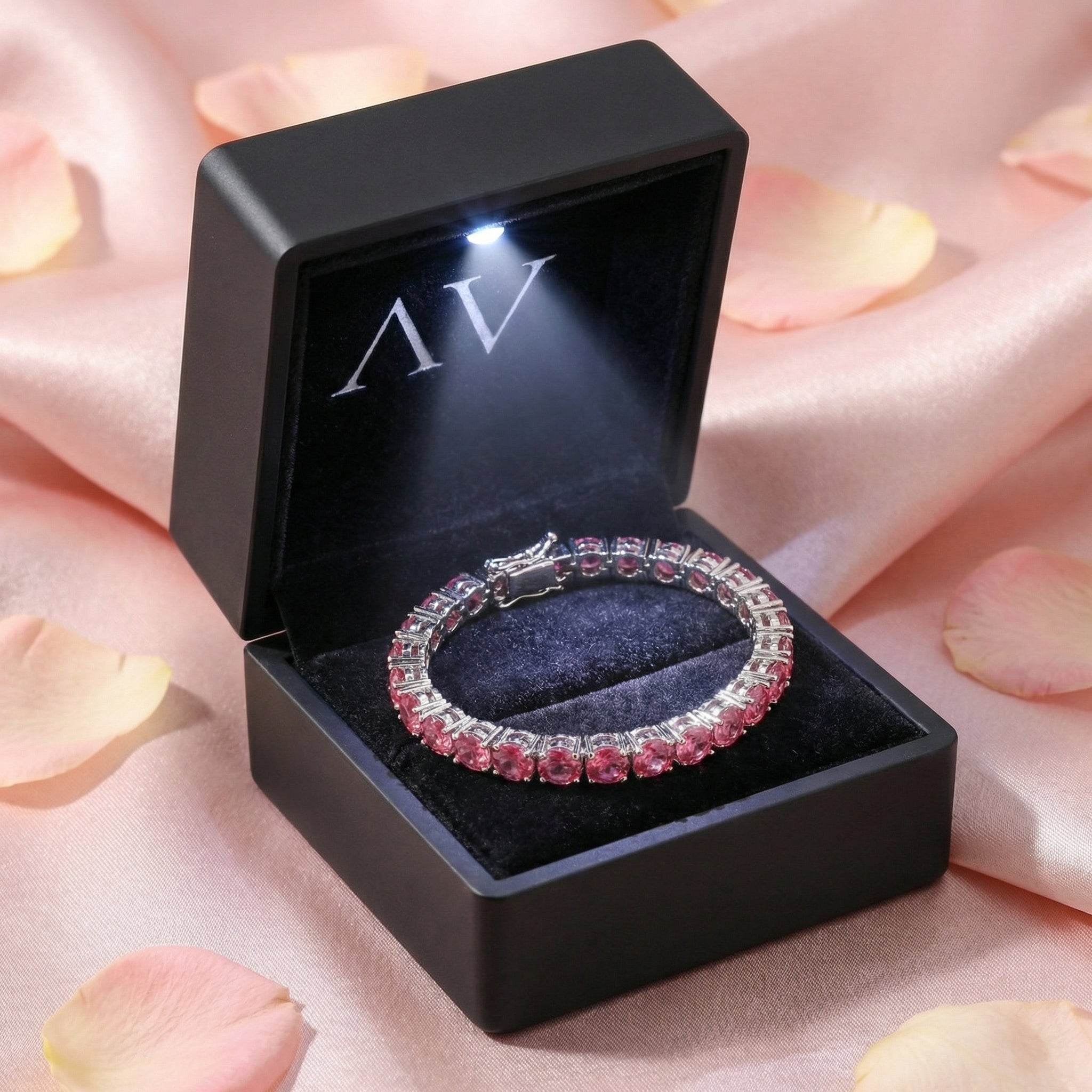 Stainless steel pink tourmaline tennis bracelet presented in a black light-up gift box with LED illumination.