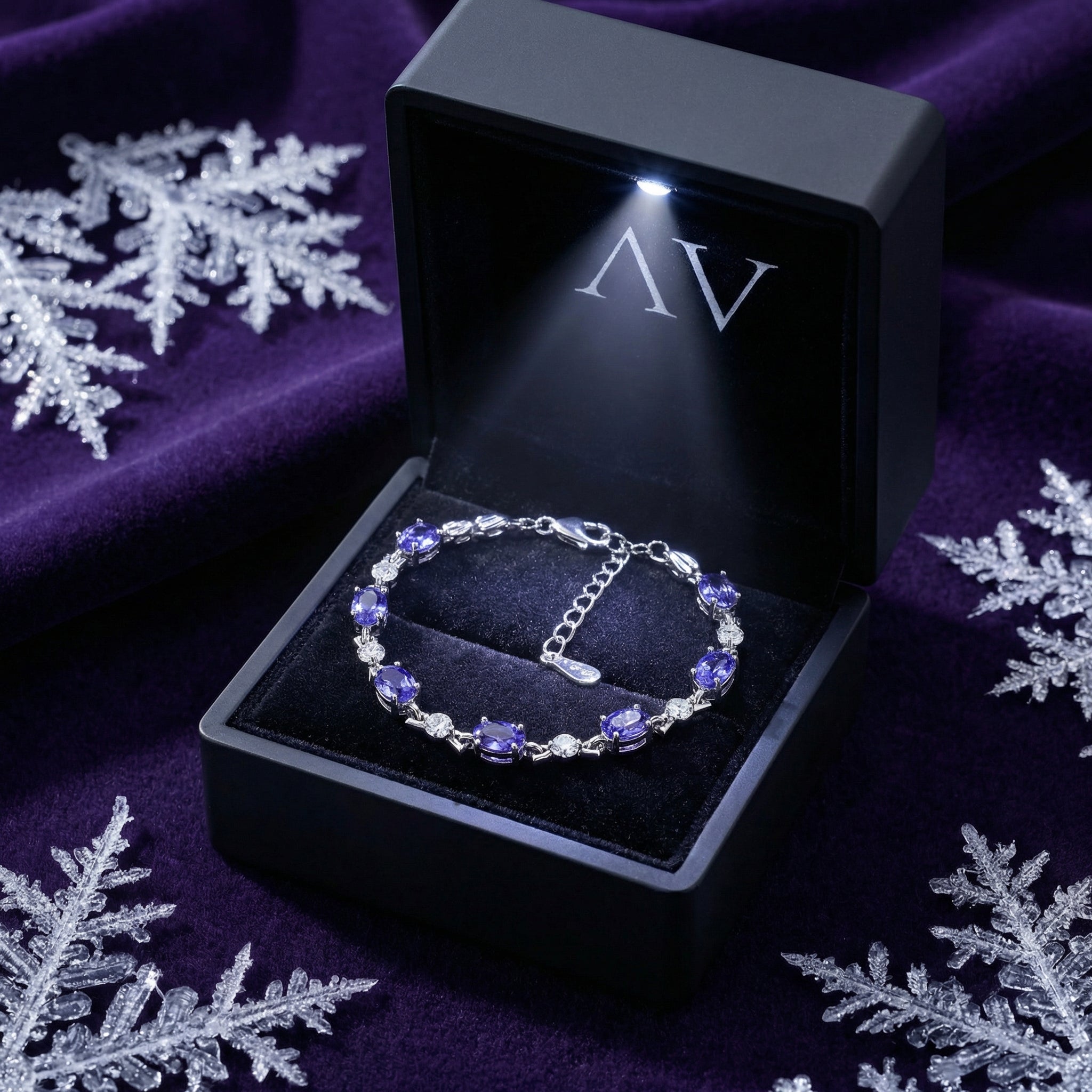 Oval simulated tanzanite sterling silver bracelet inside a black LED-lighted jewelry presentation box.