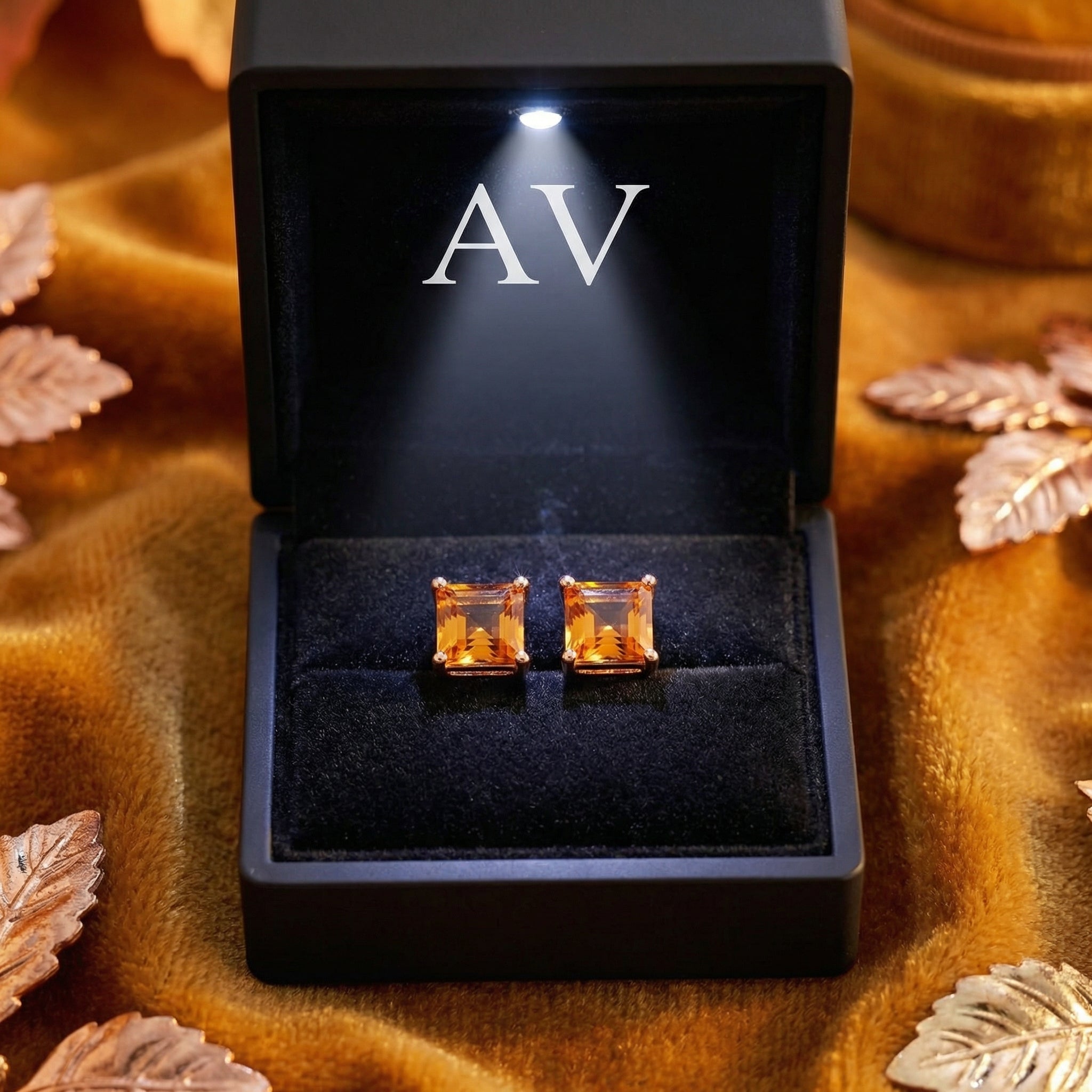 Square-cut simulated topaz stud earrings in 18K rose gold vermeil inside a lighted black presentation box.
