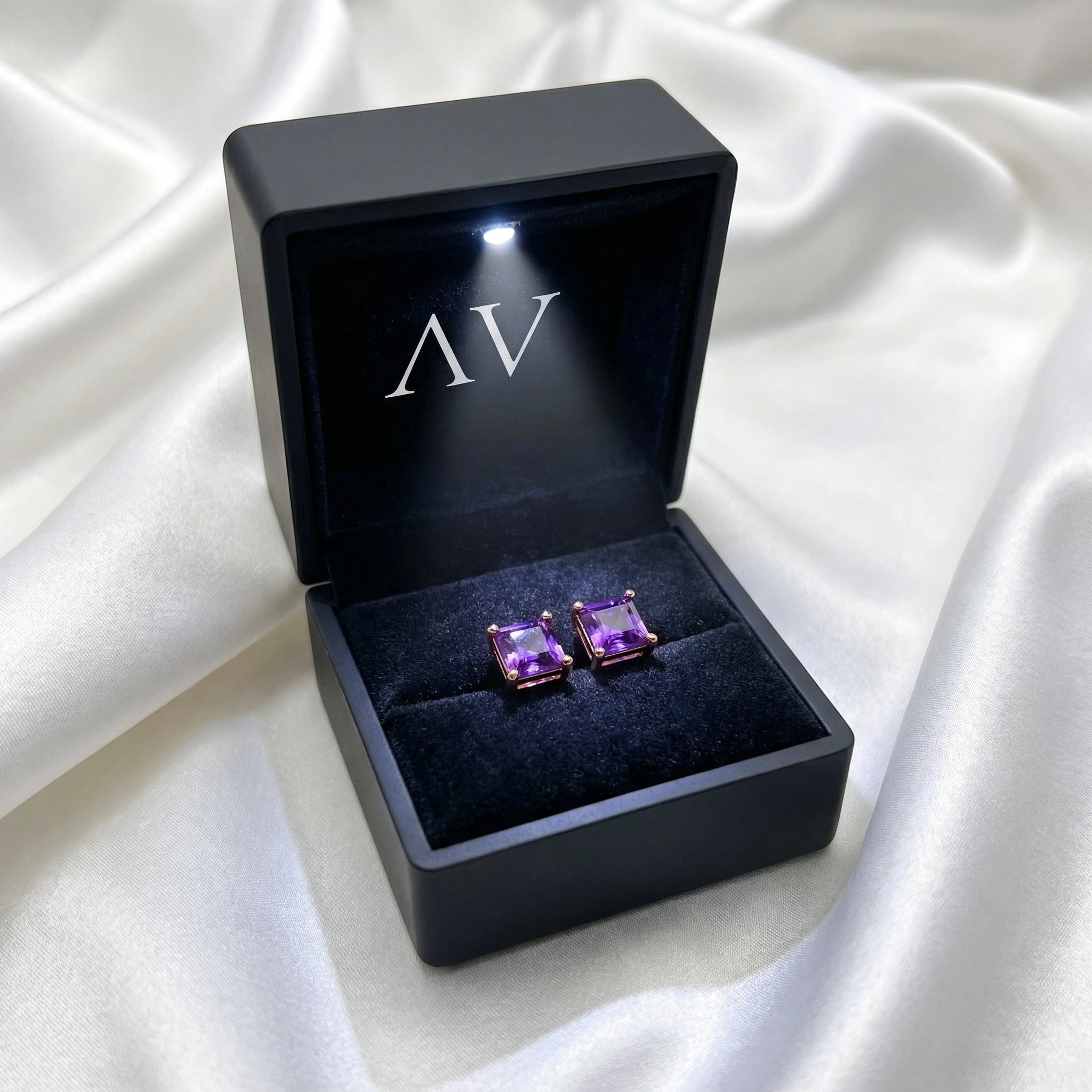 Square cut simulated amethyst stud earrings in 18K rose gold vermeil inside a premium lighted jewelry box.