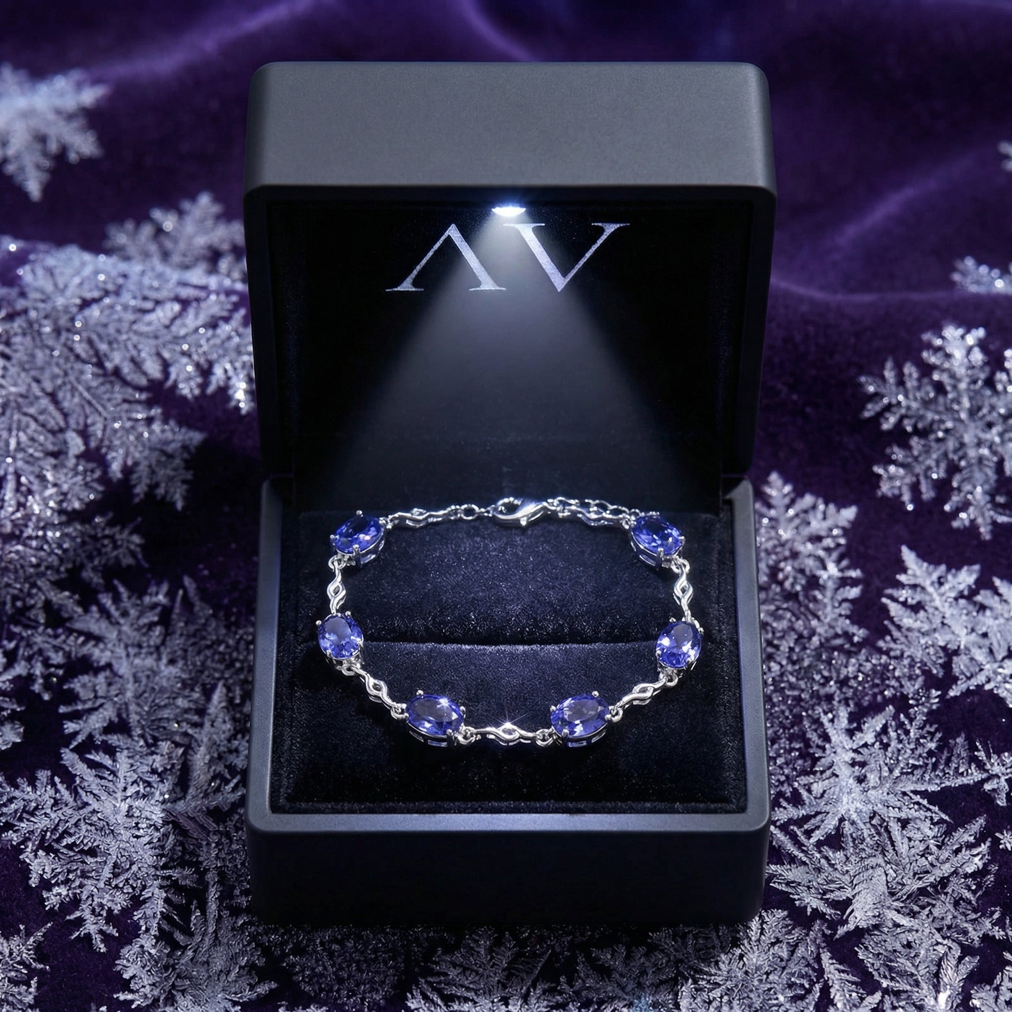 Melisara sterling silver and simulated tanzanite bracelet inside a black LED-lighted jewelry presentation box.