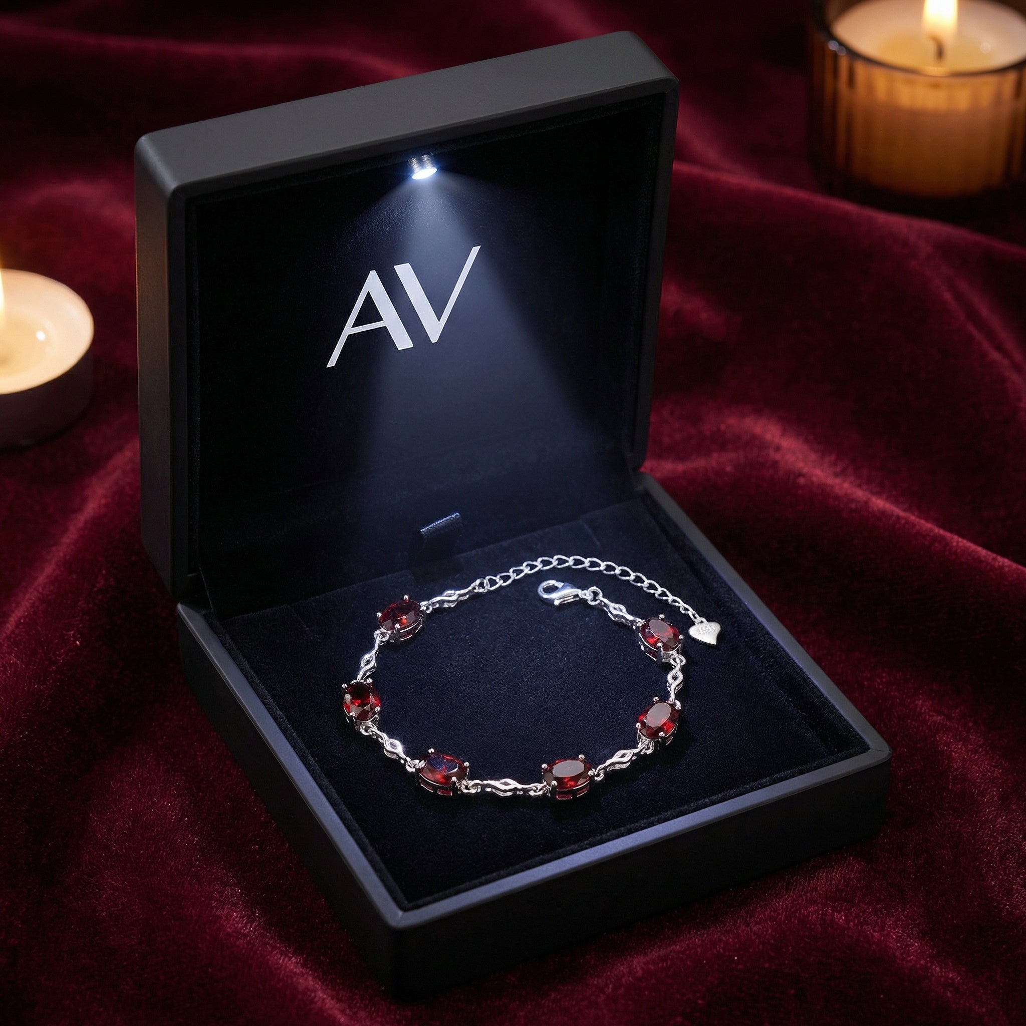Valora silver station bracelet with red simulated garnets inside a black LED-lit jewelry presentation box.