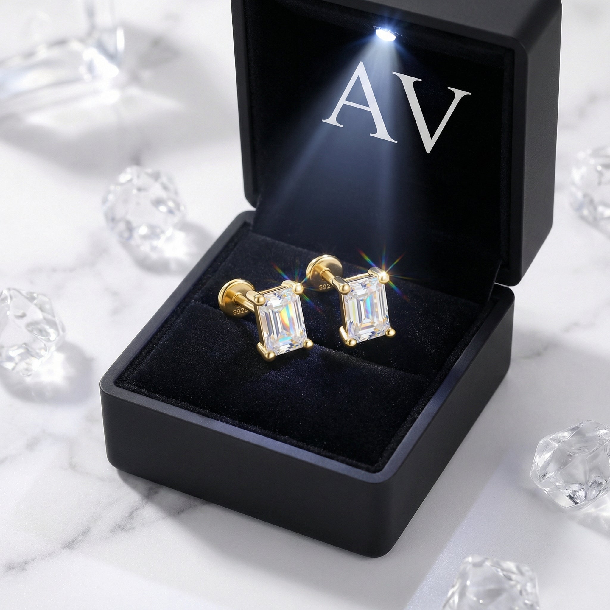 Baguette cut simulated diamond stud earrings in 18K gold vermeil inside a lighted black jewelry box.