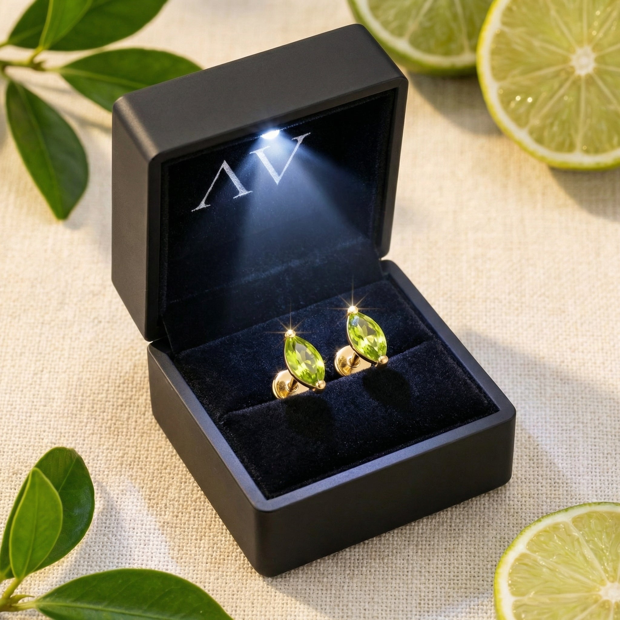 Marquise-cut simulated peridot earrings in 18K gold vermeil inside a lighted black jewelry gift box.