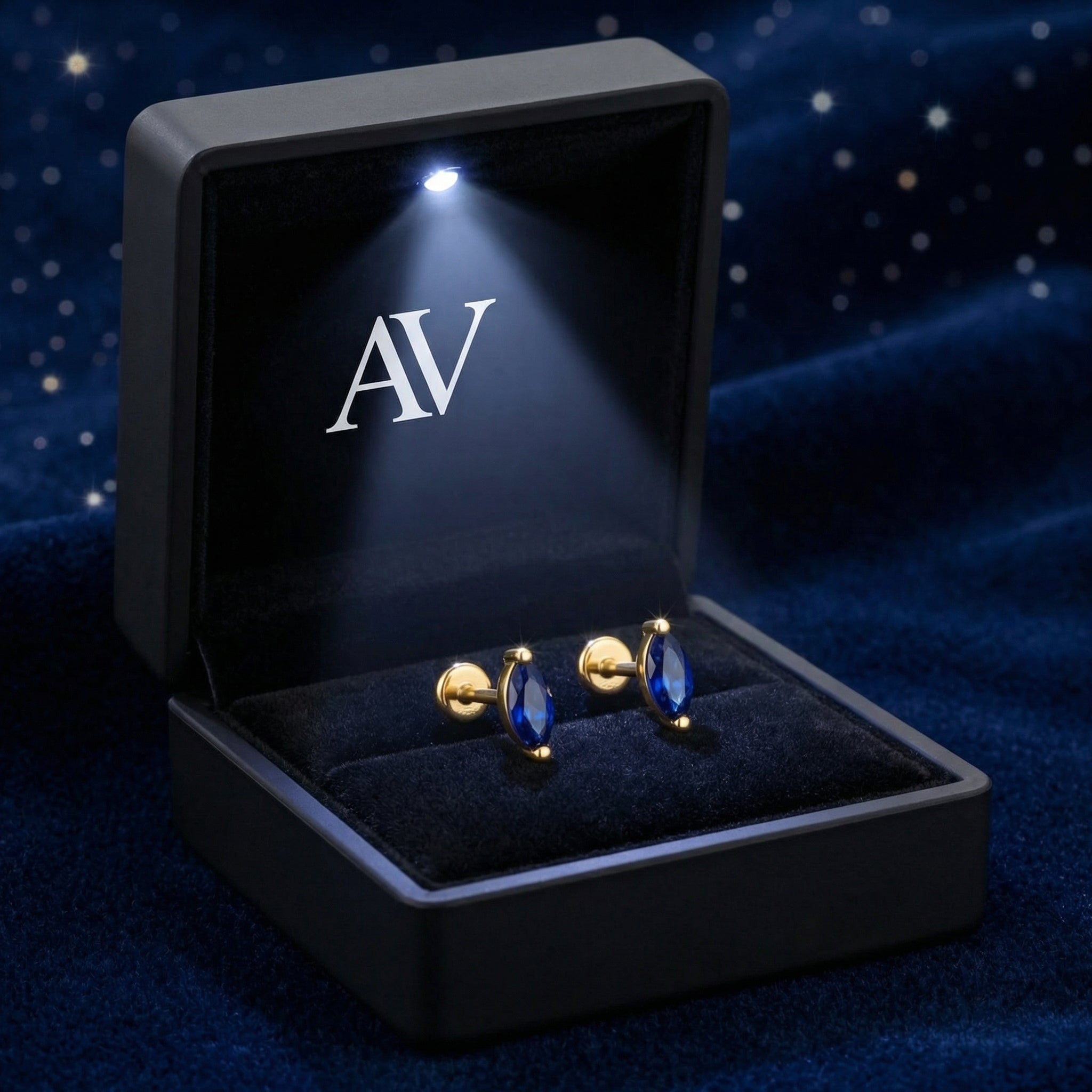 Marquise cut simulated sapphire gold vermeil earrings inside a black LED-lighted jewelry box on blue velvet.
