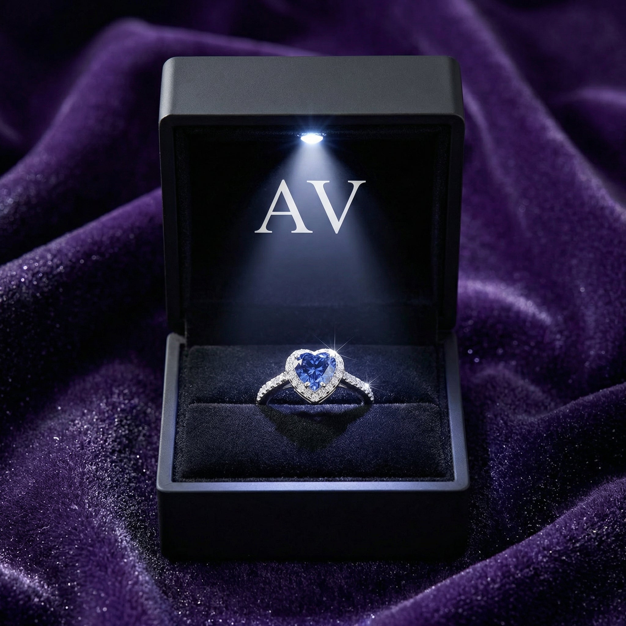Heart-shaped simulated tanzanite sterling silver ring inside a black LED-lit jewelry presentation box.
