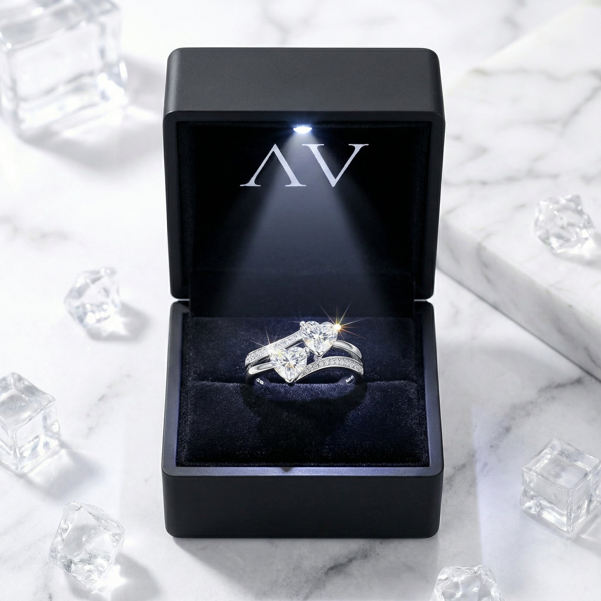 Amantina heart bypass ring in S925 sterling silver presented in a black LED-lit jewelry gift box on marble.