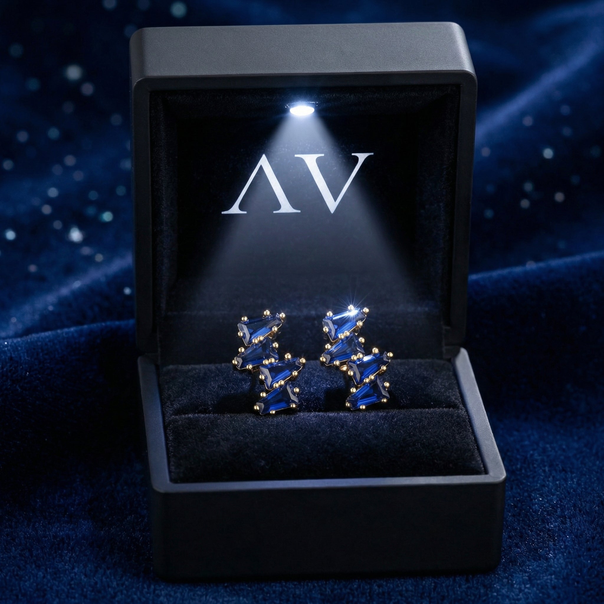Vesperis blue simulated sapphire cluster earrings inside a lighted black AV branded jewelry gift box.