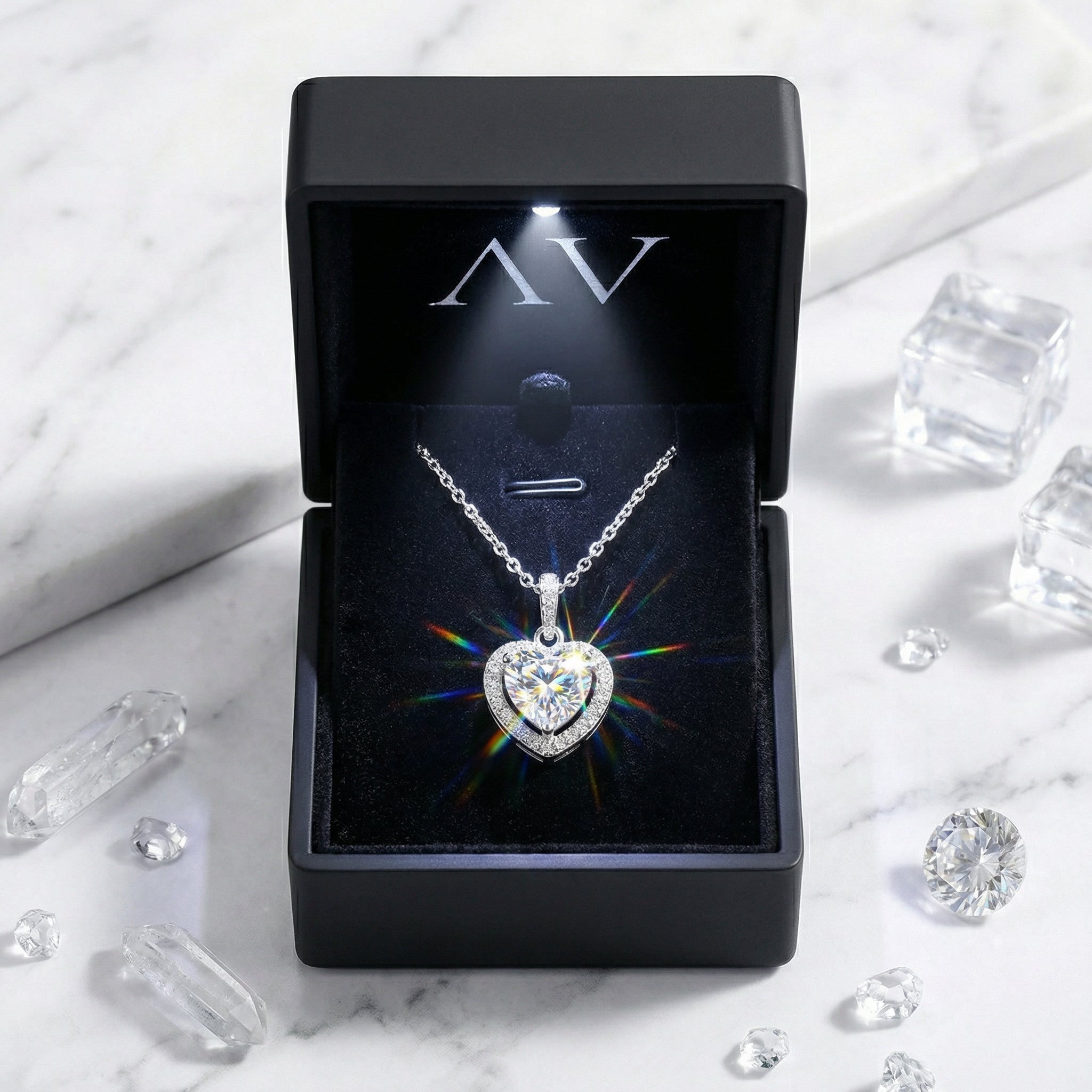 Heart-shaped simulated diamond necklace in a lighted black gift box showing rainbow fire and dispersion.