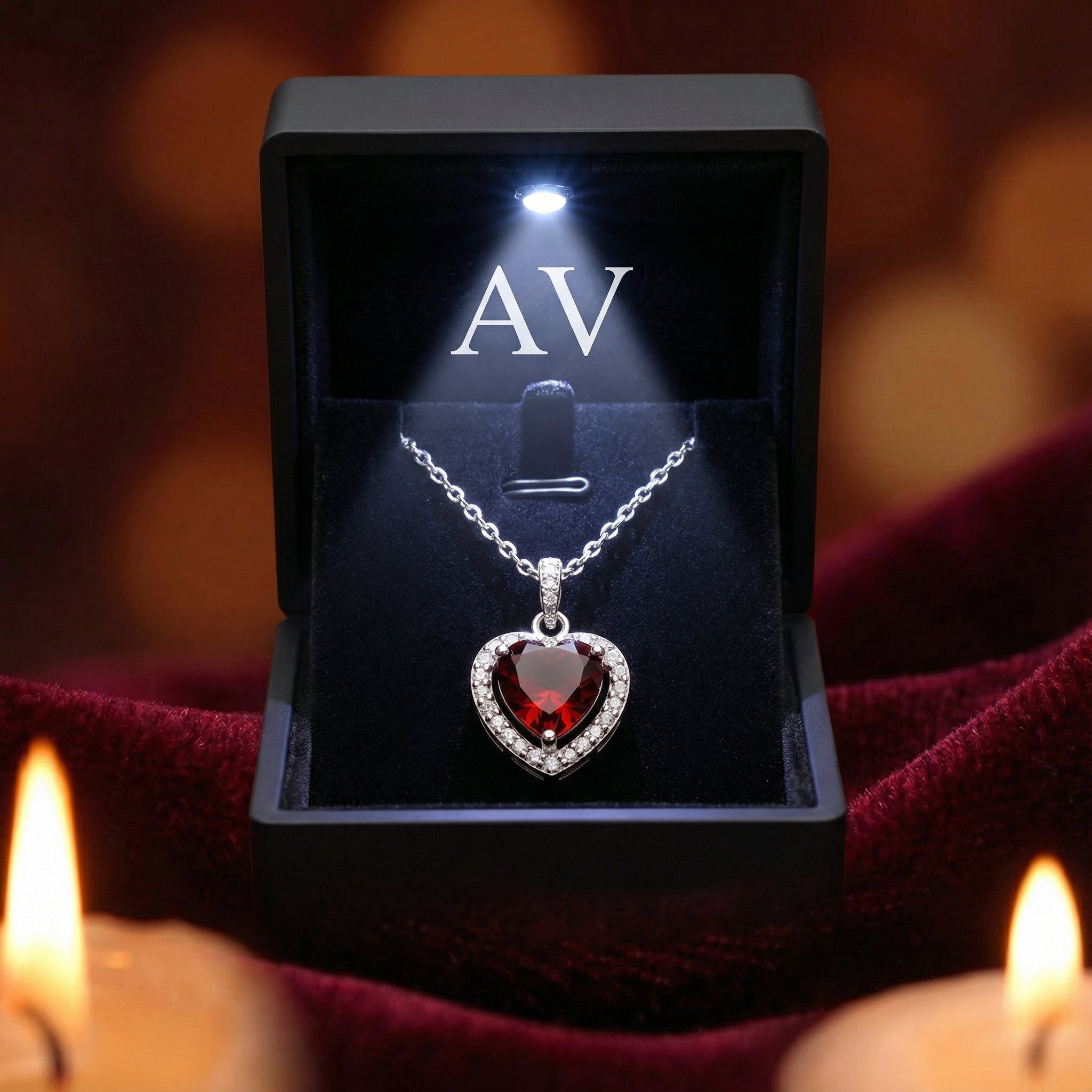 Heart-cut red garnet silver necklace displayed in a black LED-lighted jewelry gift box on red velvet.