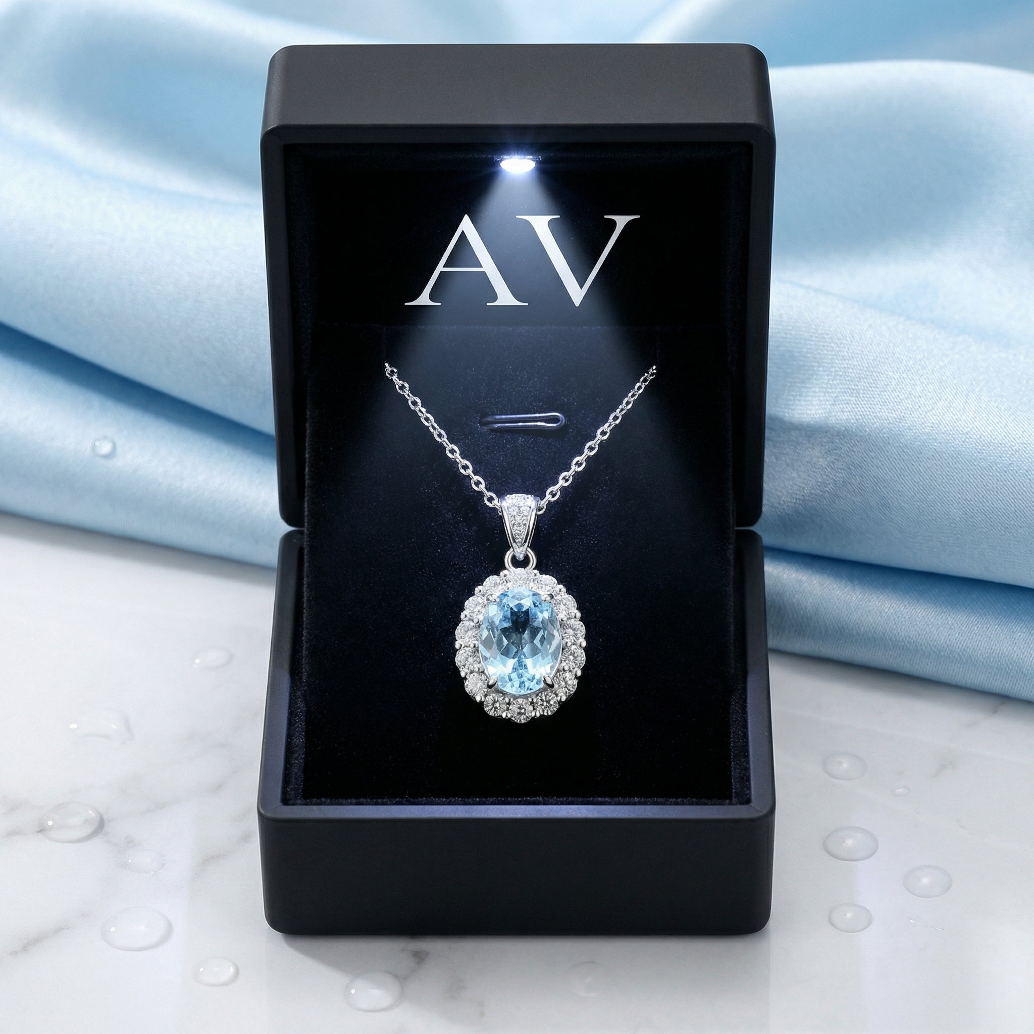 Oval simulated aquamarine halo necklace in a black LED-lighted gift box with silver chain.
