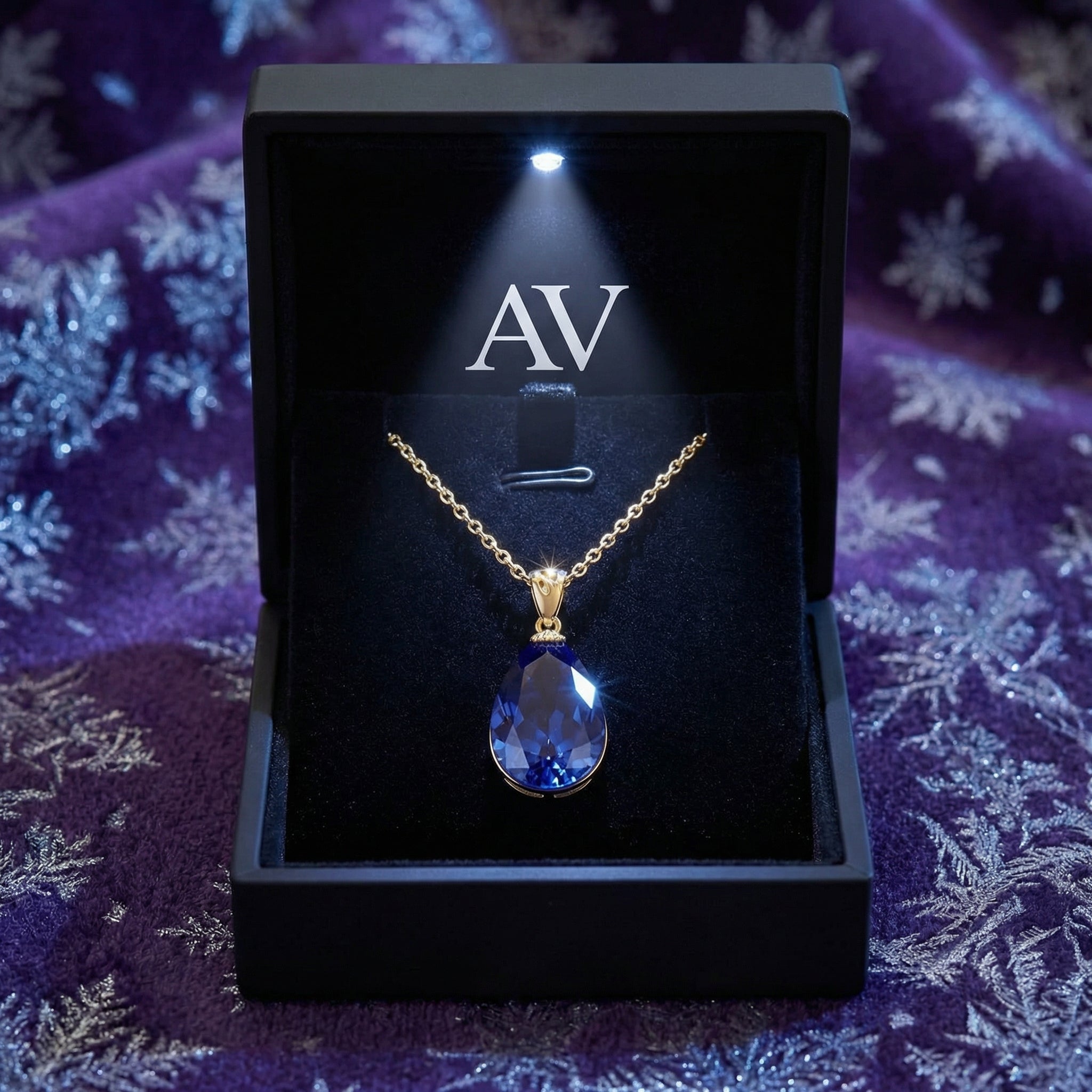 Pear-cut simulated tanzanite necklace in 18K gold vermeil inside a lighted black jewelry gift box.