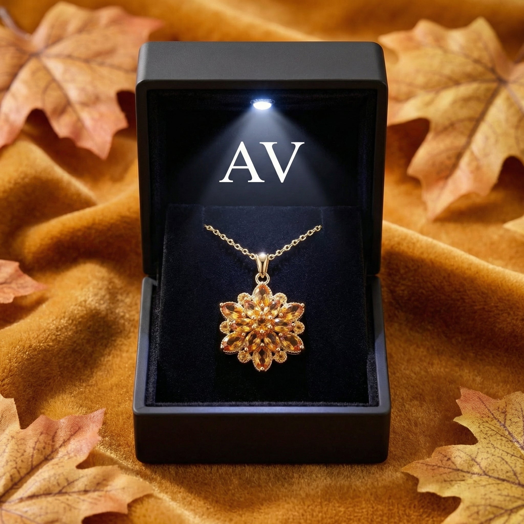 Gold November birthstone necklace inside a black LED-lit jewelry box with autumn leaf accents.