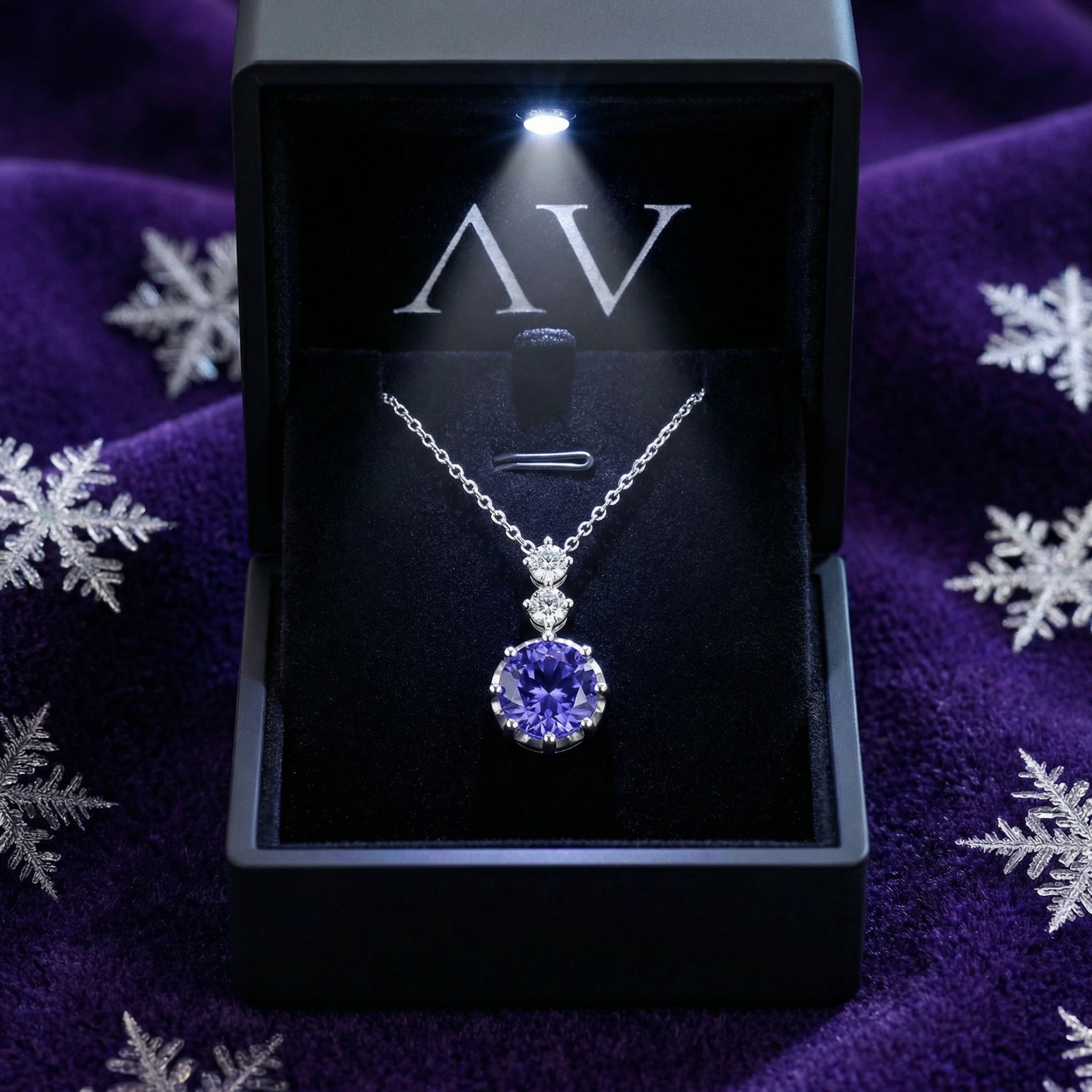 Sterling silver simulated tanzanite pendant necklace inside a lighted black jewelry presentation box.