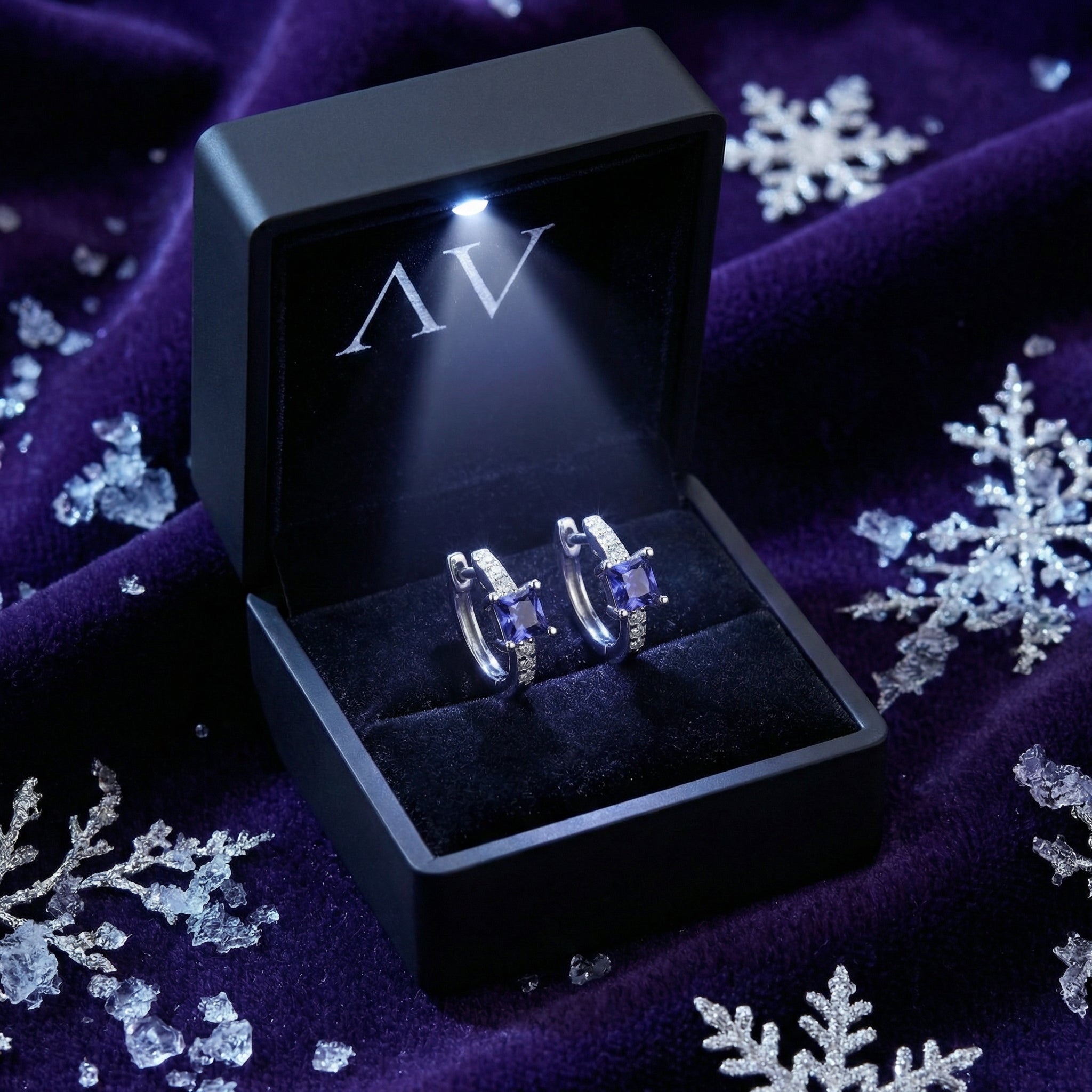 Sterling silver simulated tanzanite hoop earrings inside a black lighted jewelry presentation box.