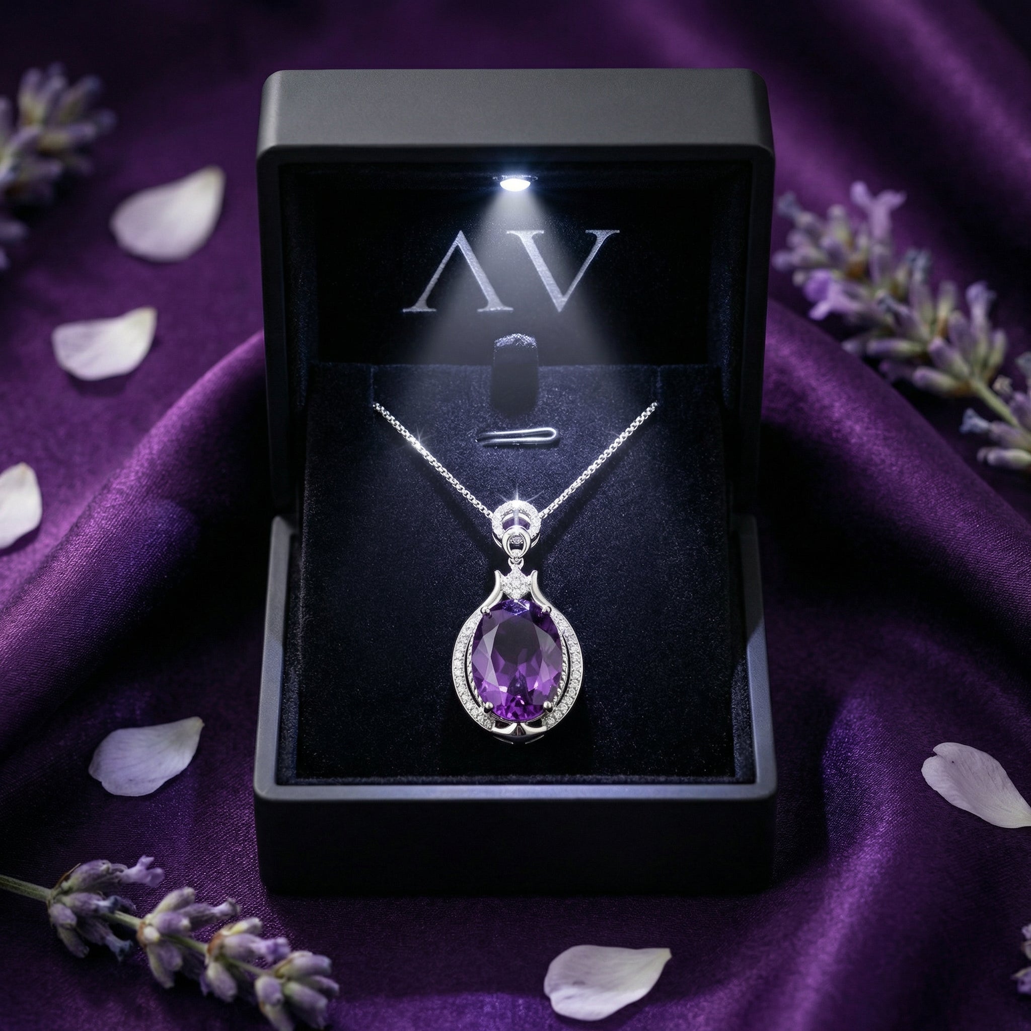 The Victoria oval amethyst pendant presented in a black LED-lighted gift box on purple silk.