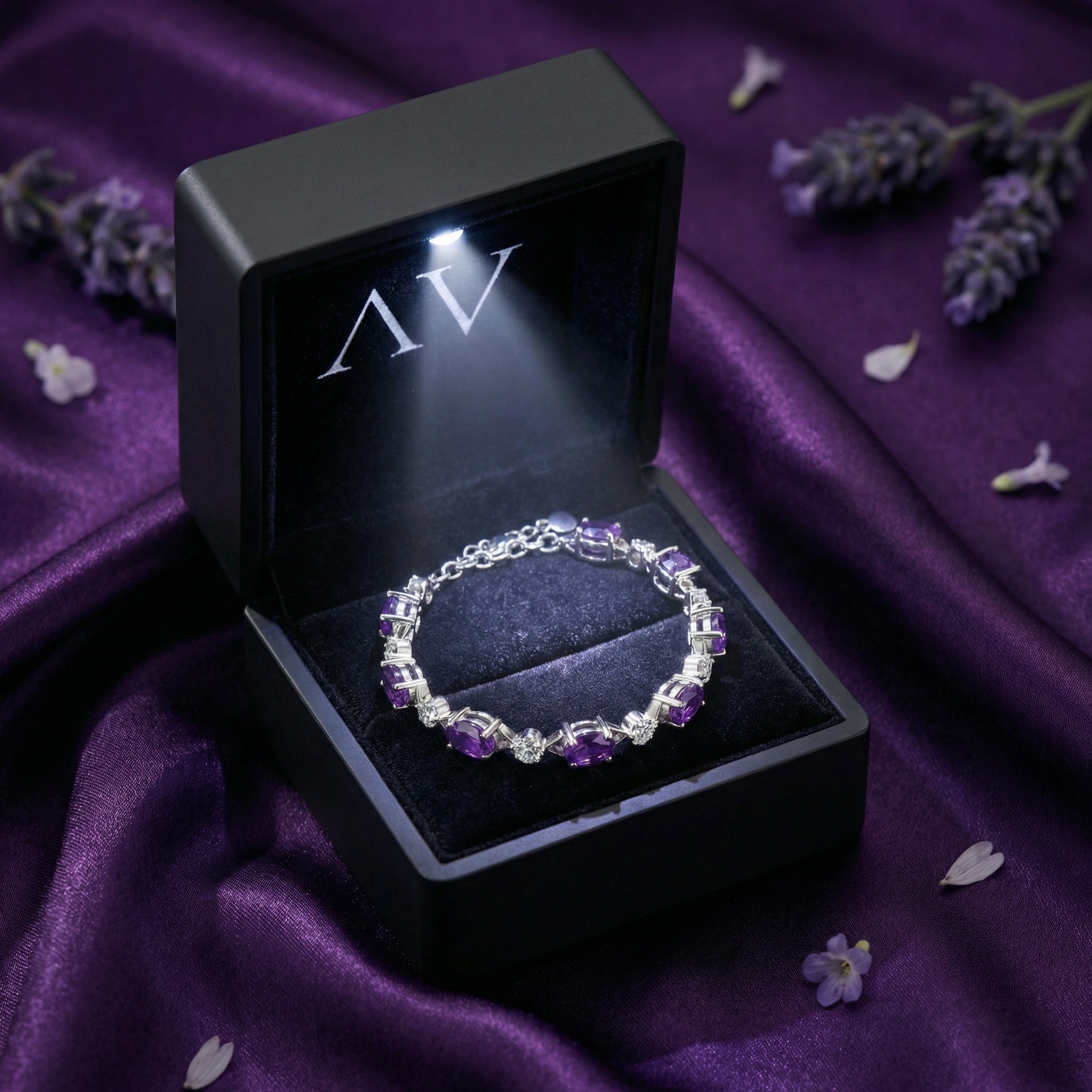 Verona oval amethyst station bracelet in S925 sterling silver inside a black lighted gift box.