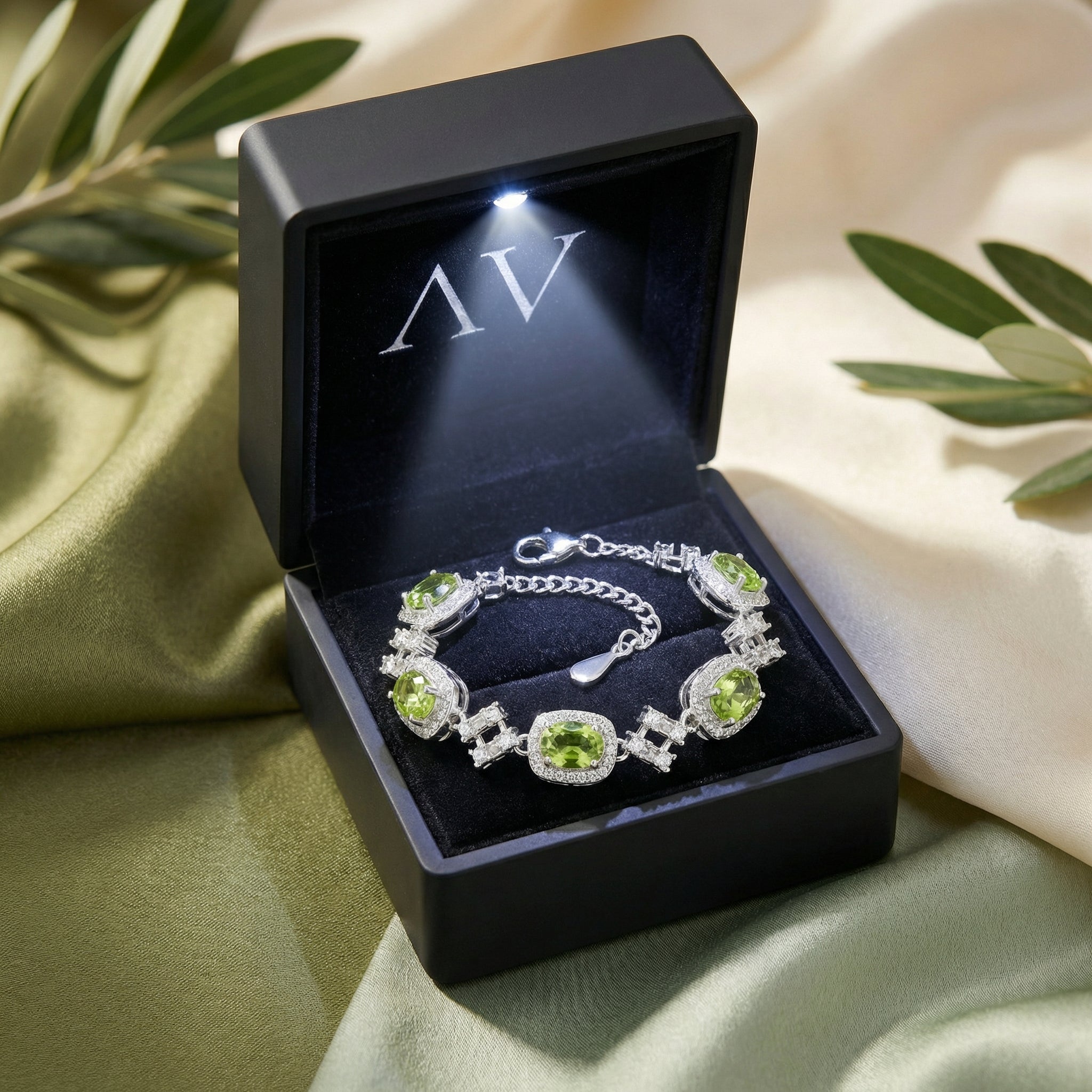 S925 sterling silver peridot station bracelet inside a premium lighted black jewelry presentation box.