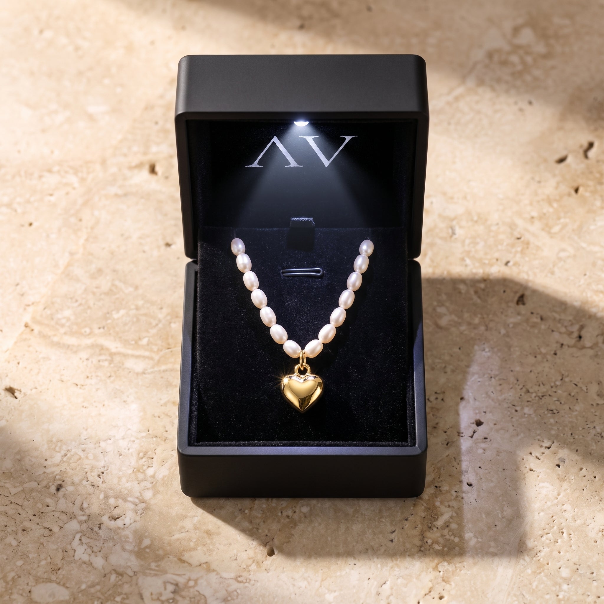 The Colette Pearl Necklace, a solid yellow gold heart and white synthetic pearl necklace.