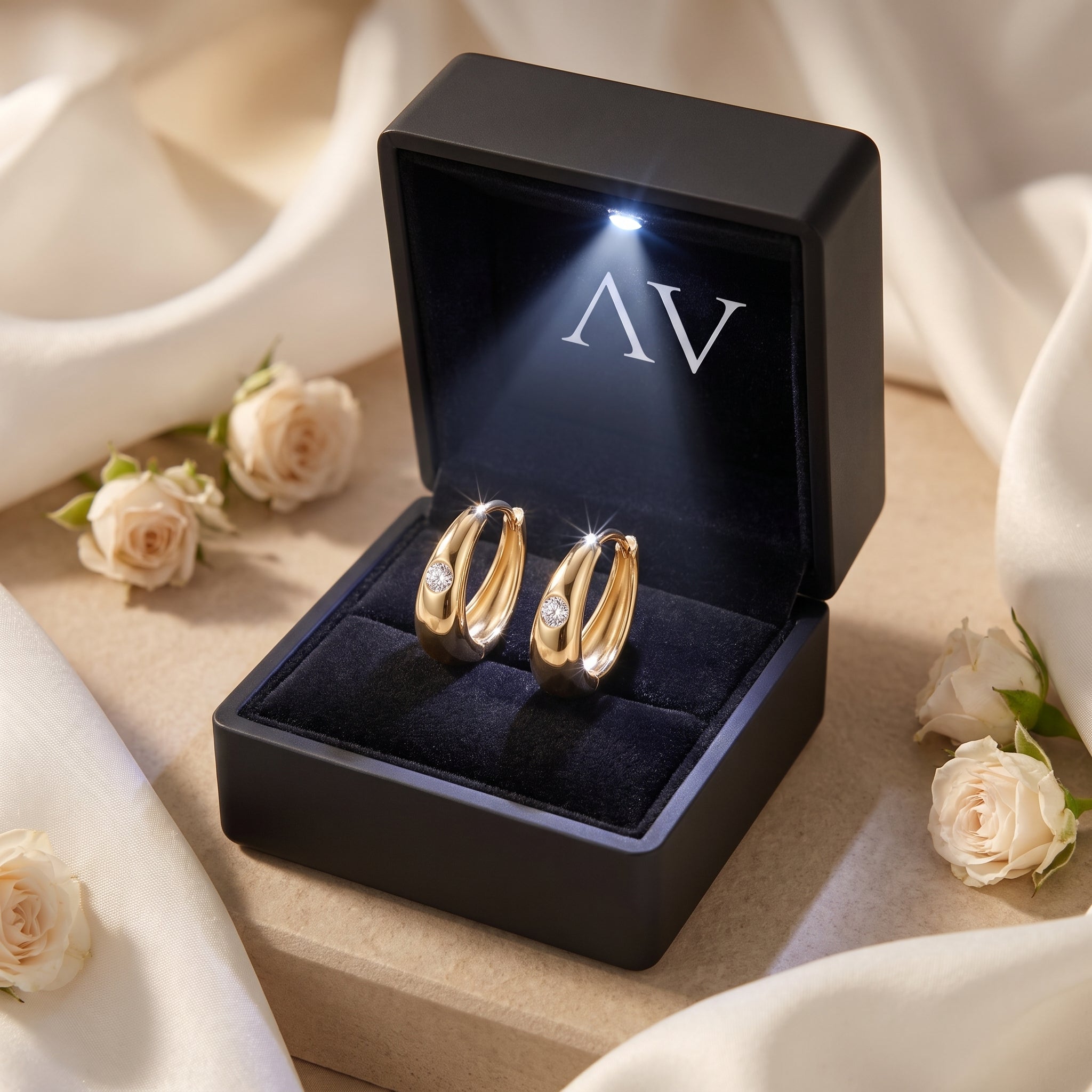 Gold moissanite hoop earrings with round-cut stones inside an LED-lit gift box.