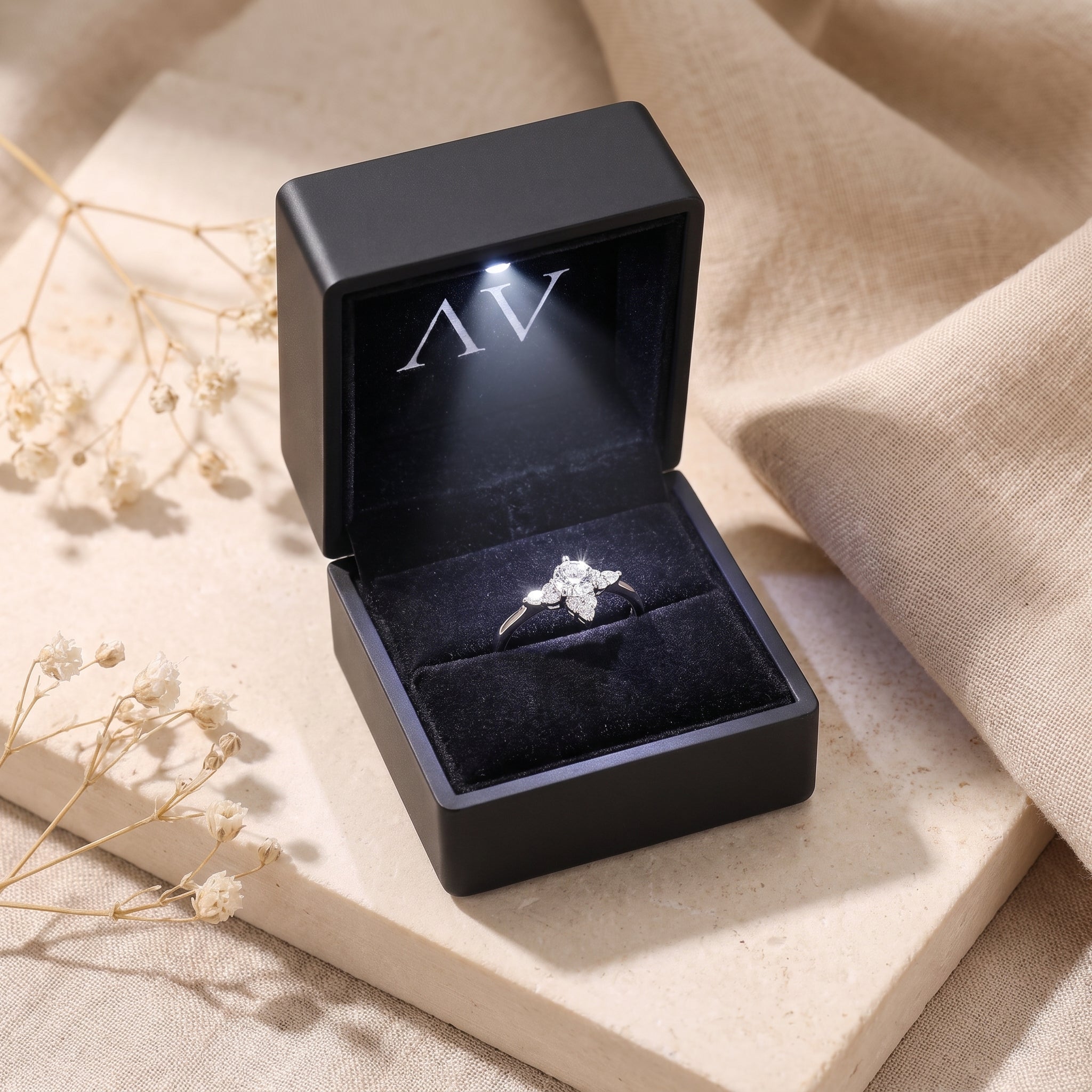 Silver Lysianna ring presented in a premium black lighted gift box on a neutral textured surface.