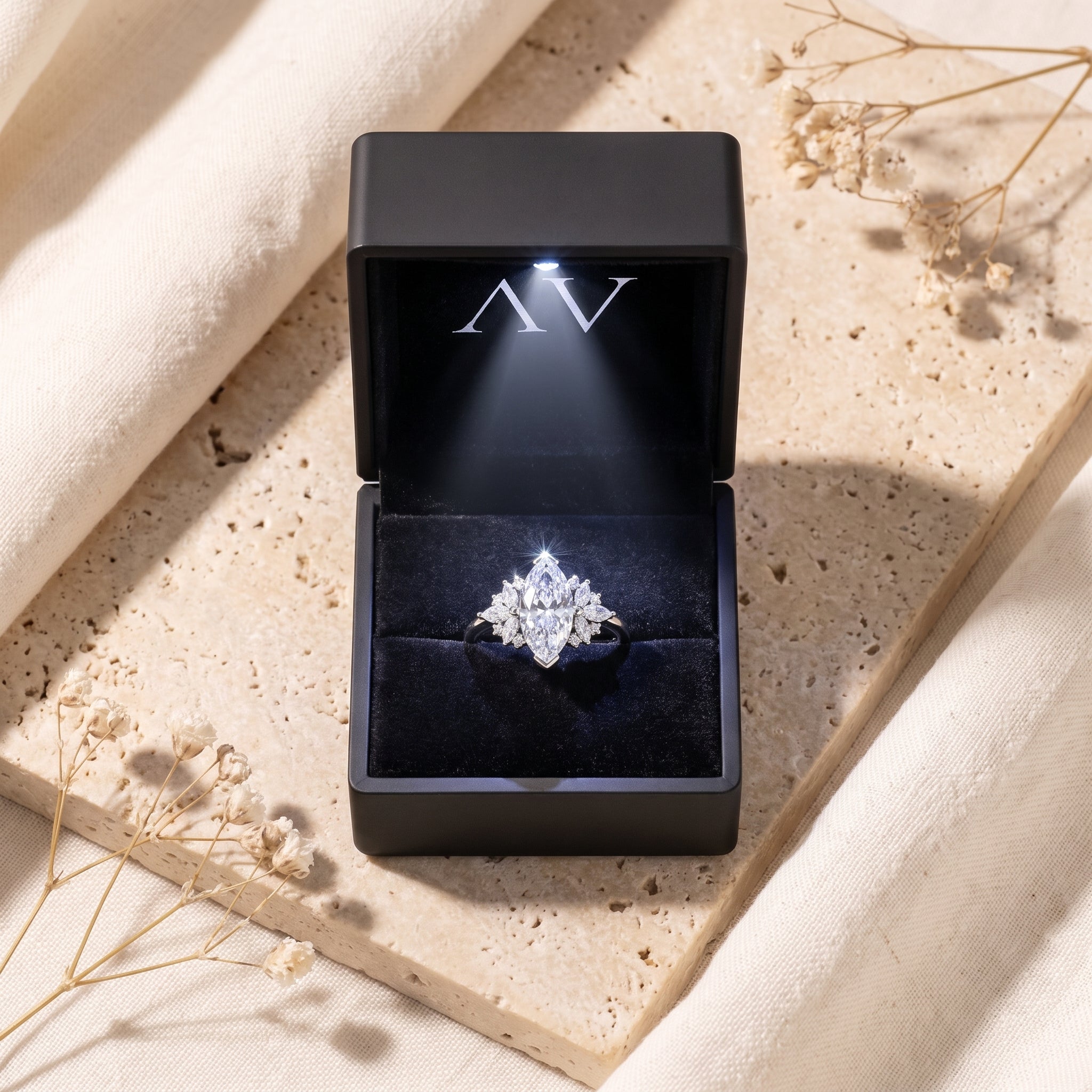 Silver marquise moissanite ring presented in a black LED-lit jewelry gift box.