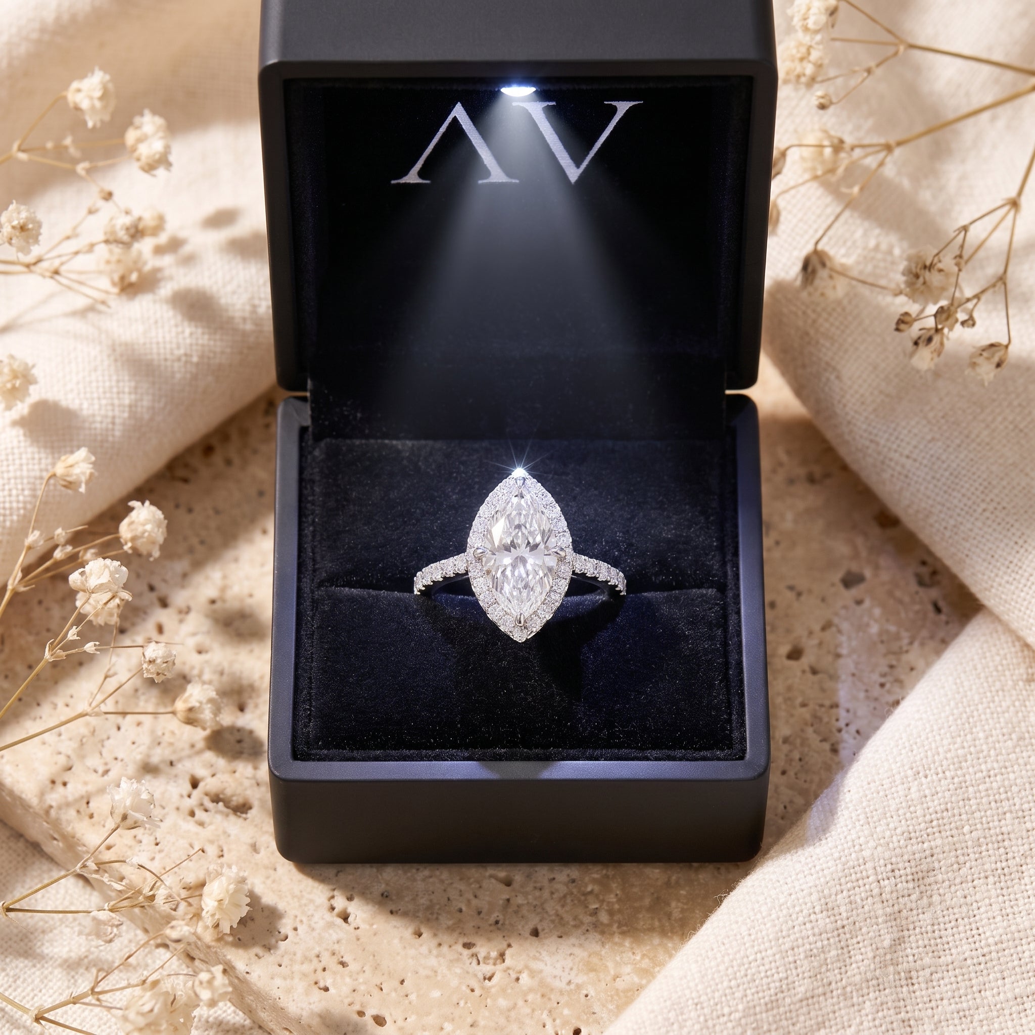 Marquise moissanite halo ring presented in a black LED lighted jewelry box.